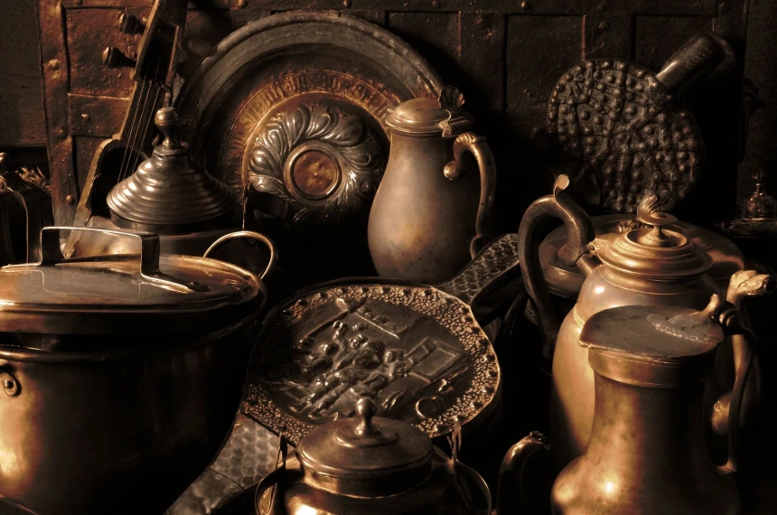 A group of antique pots and pans on display.