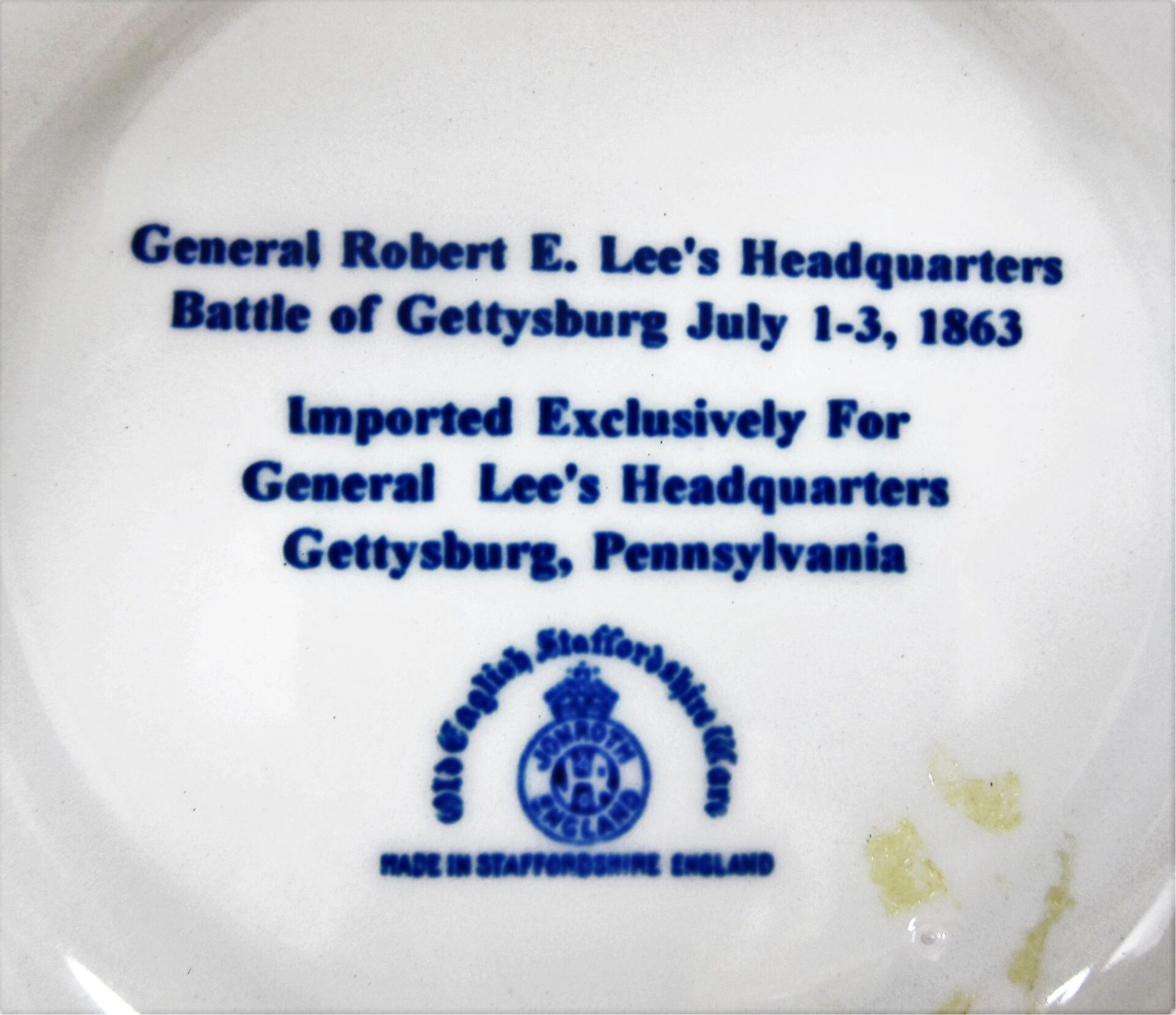 White plate featuring blue text: “Gettysburg Souvenir Plate Depicting General Lee's Headquarters. Imported exclusively for General Lee’s Headquarters, Gettysburg, Pennsylvania.”.