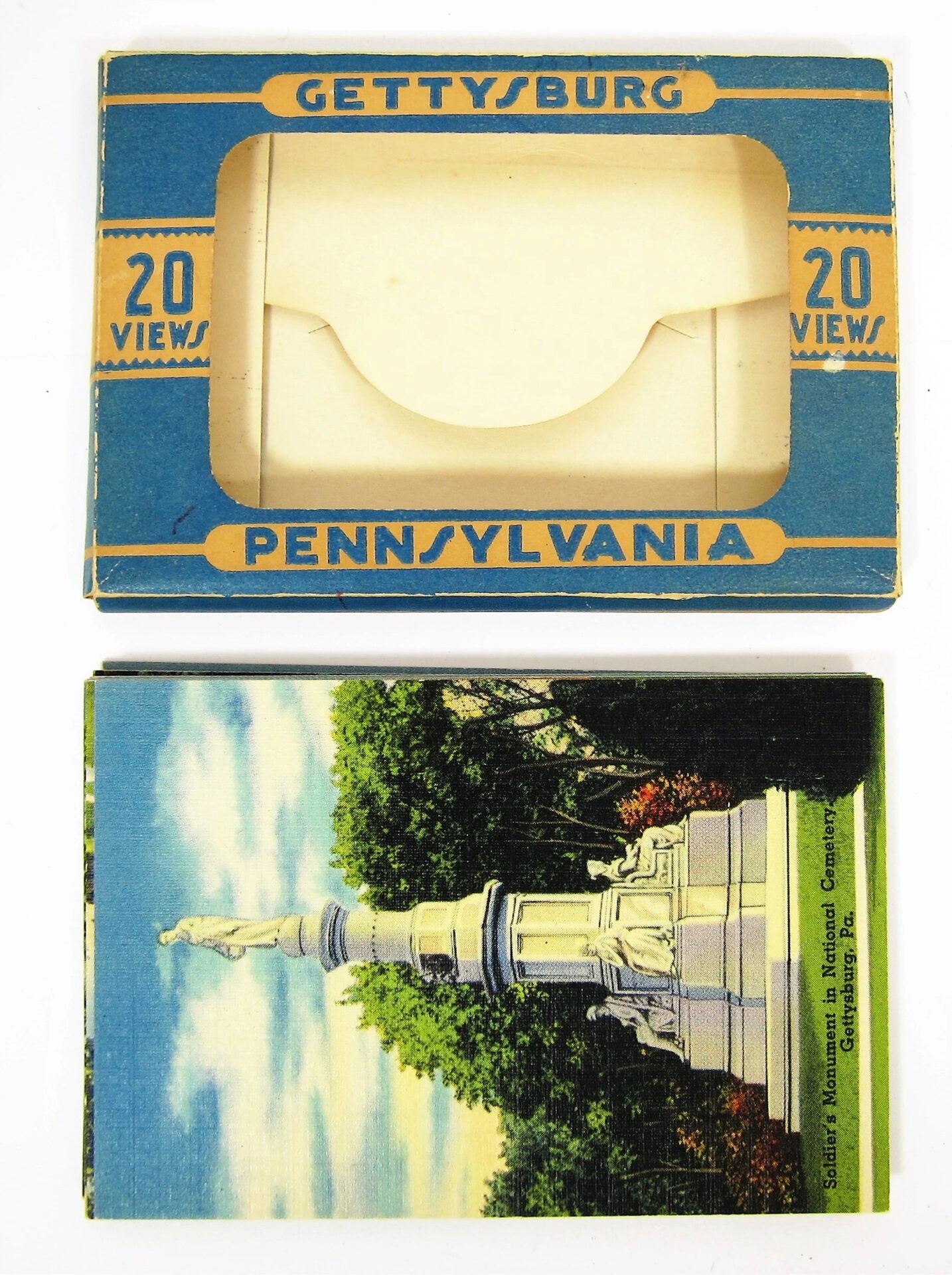 A box labeled "Gettysburg Souvenir Gettysburg Postcards" sits above a postcard showing a monument surrounded by trees.