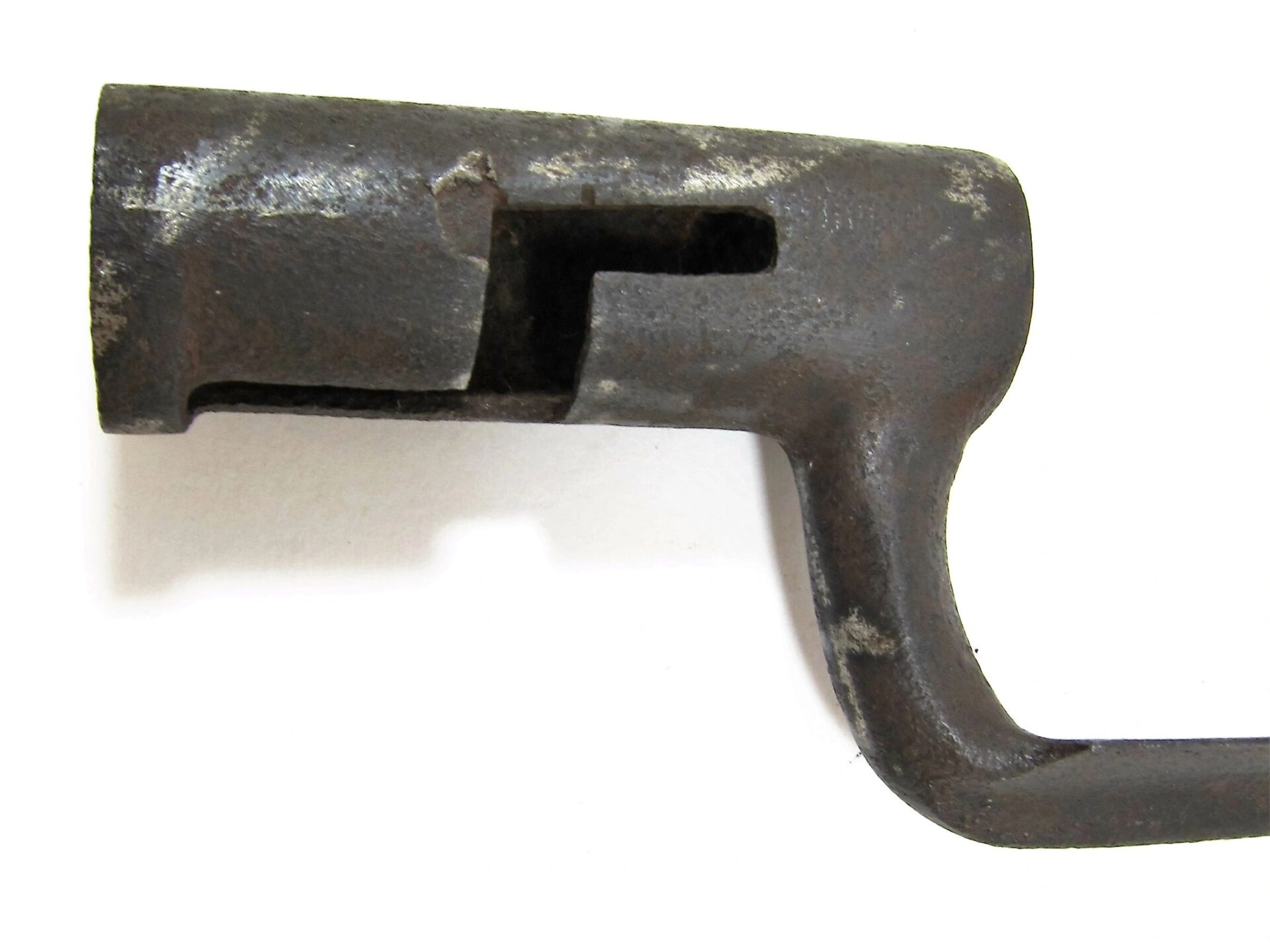 Close-up of a U.S. Socket Bayonet with a cylindrical end and right-angled handle, showing signs of rust and age against a plain white background.