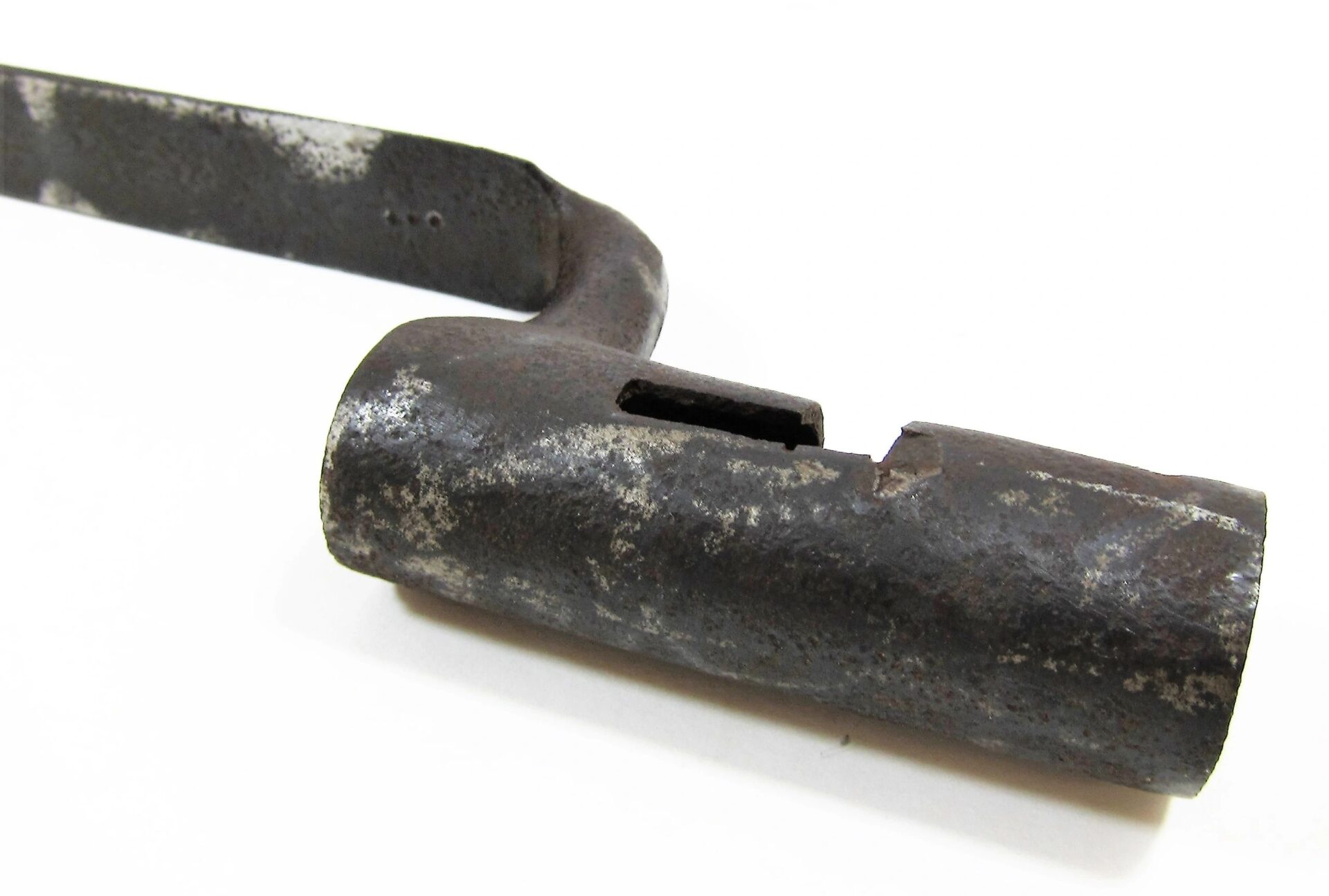 A U.S. Socket Bayonet, featuring a cylindrical, notched end and showing signs of rust and age, is displayed on a white background.