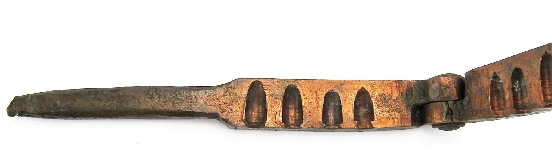 A close-up of a Civil War Era Bullet Gang Mold, showcasing its series of evenly spaced, arched cutouts along the length.