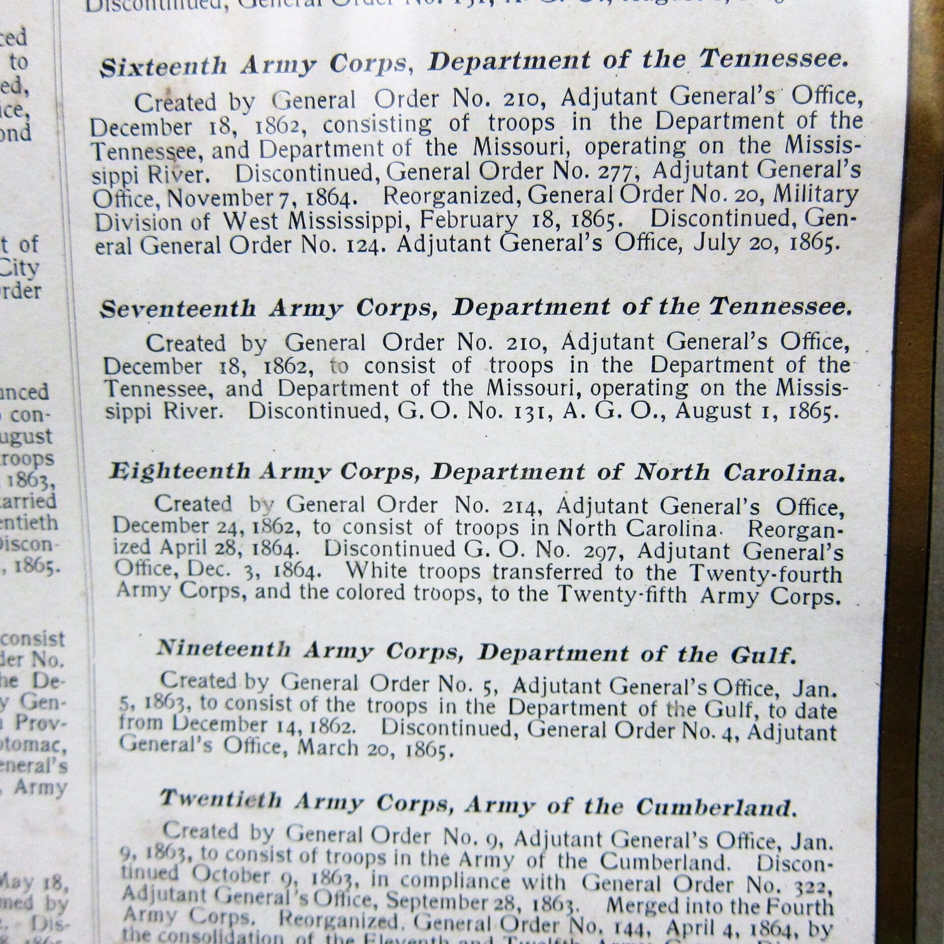 A close-up of a US Army Corp Escutcheon book page detailing various Corps during the Civil War, including their creation and reorganization dates and locations.
