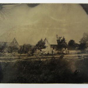 Civil War Outdoor Tintype showing a black-and-white vintage photograph of a rural homestead with multiple wooden buildings, trees, and fenced areas in the foreground.