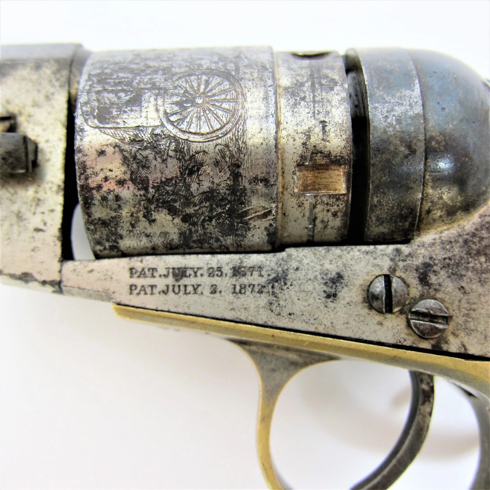 Close-up of the Colt Wells Fargo Conversion, highlighting engraved cylinder details and patent dates stamped on the metal frame above the trigger.