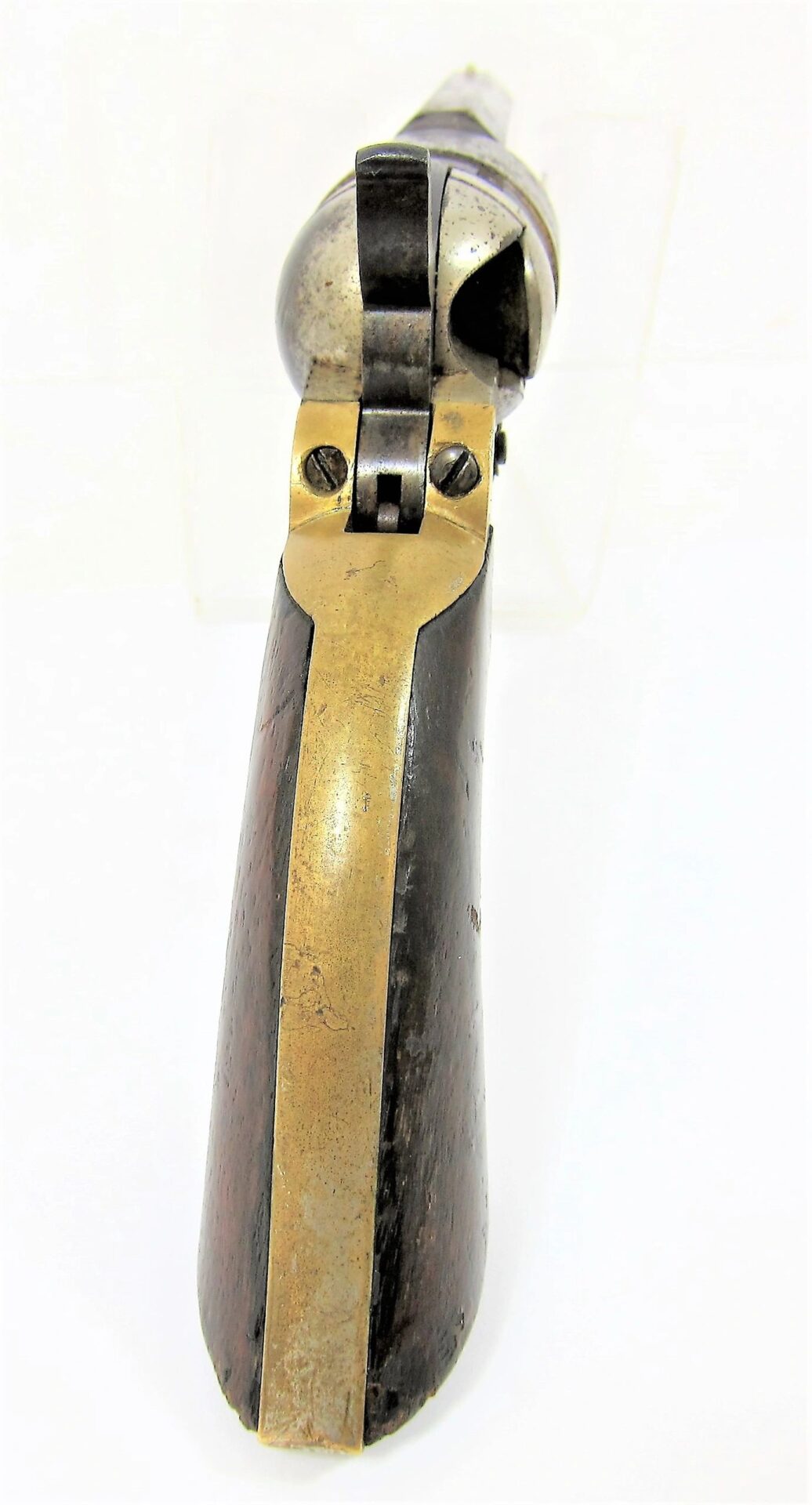 Close-up rear view of a Colt Wells Fargo Conversion revolver handle, showcasing its wooden grip and brass backstrap.