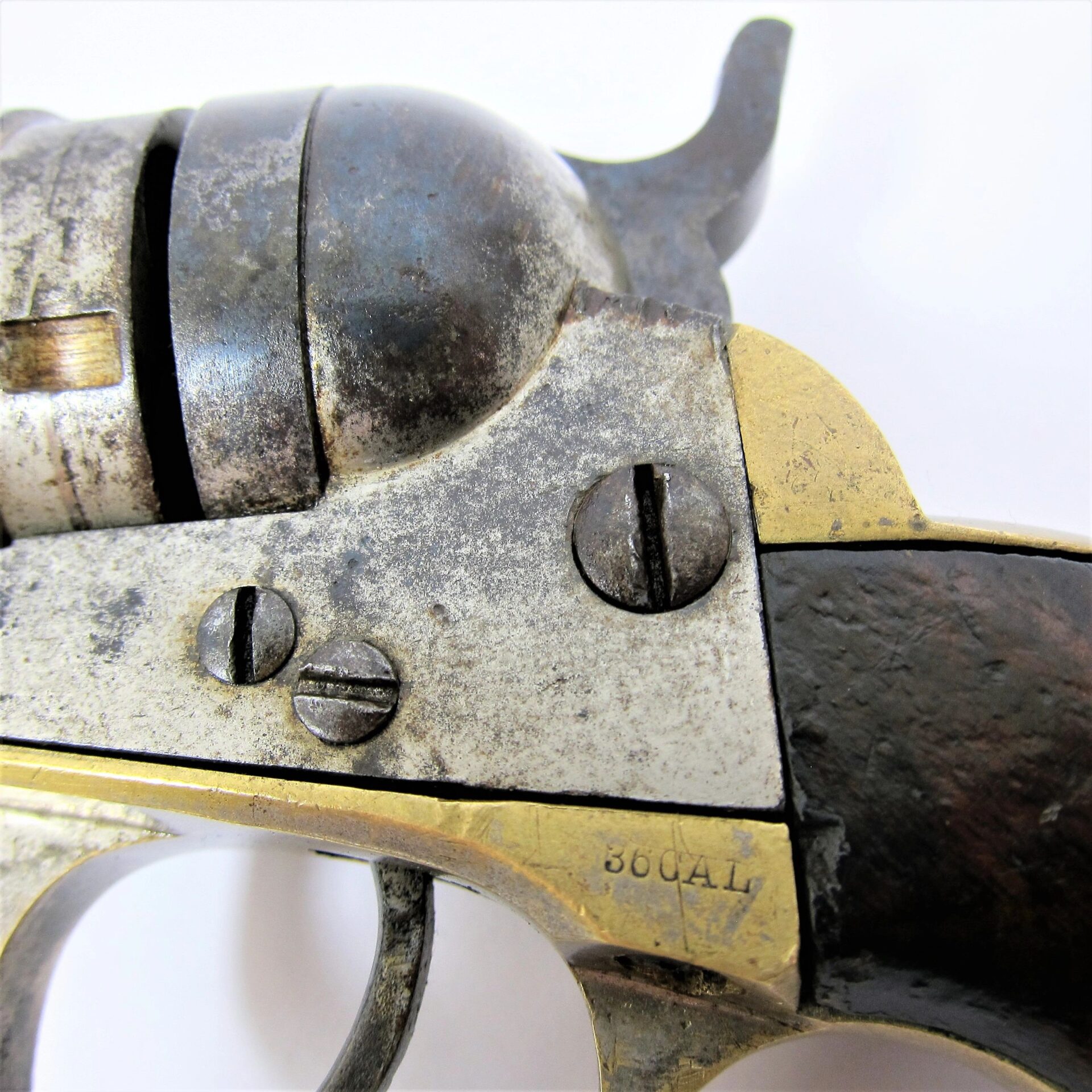 Close-up of the metal and wooden parts of a Colt Wells Fargo Conversion revolver, showing screws and “36 CAL” engraved on the brass frame.
