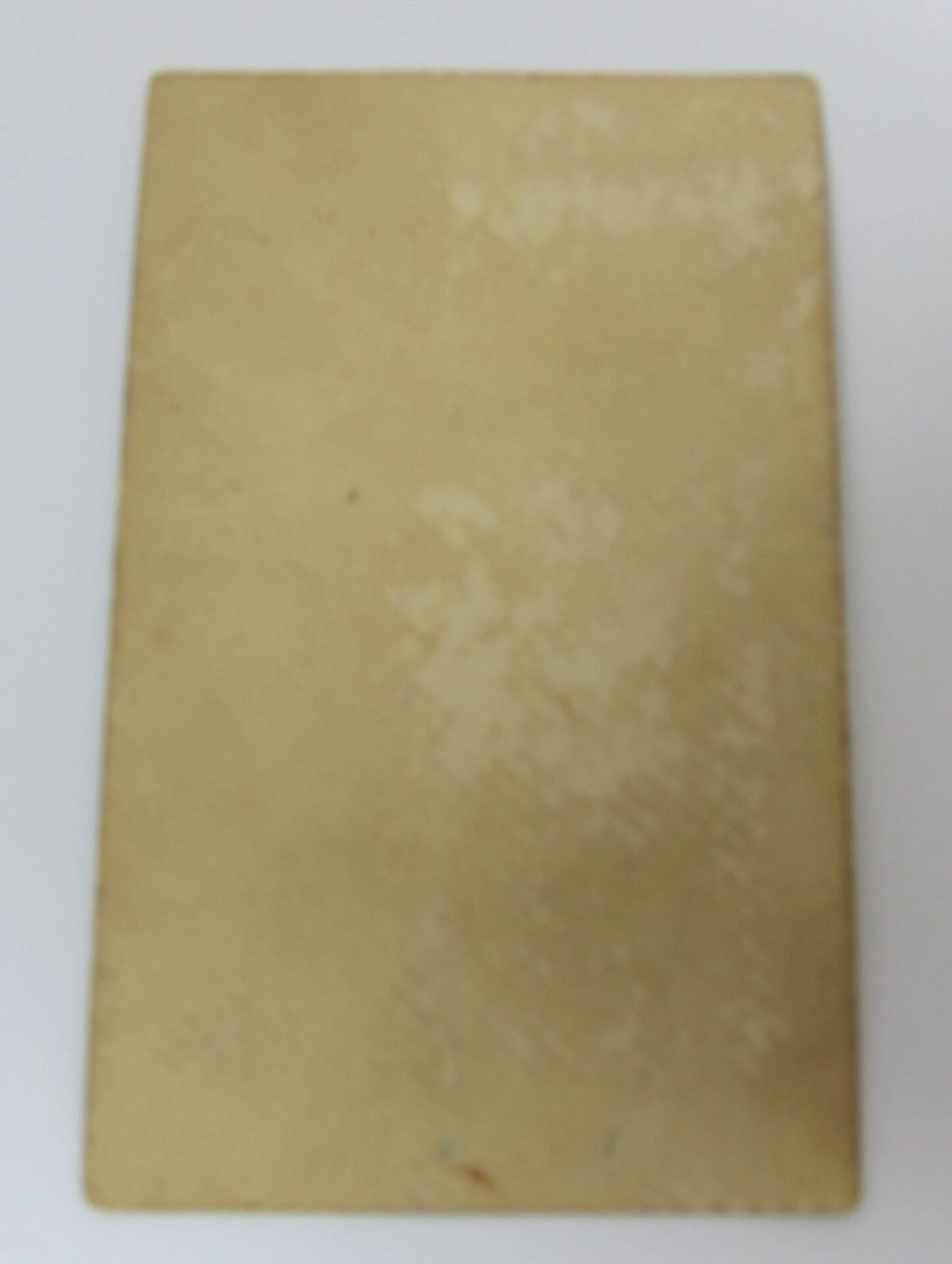 A rectangular, vertically oriented beige card featuring "Tom Thumb, Wife, and Child - Charles Sherwood Stratton" with a slightly worn, uneven surface, photographed against a plain white background.