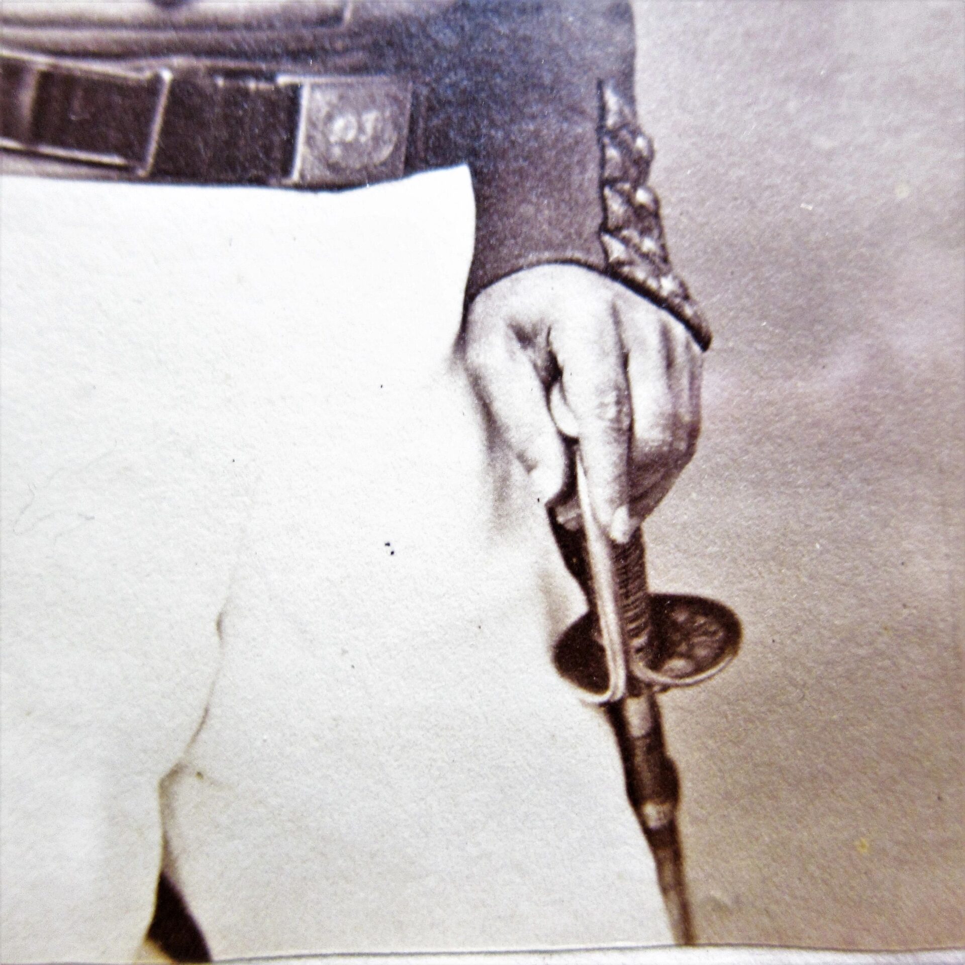 Close-up of Brevet Colonel Henry C. Shumway, Captain of the 8th Company, 7th Regiment NYSM, in uniform holding a sword by the hilt; sleeve and belt details visible. Albumen photograph.