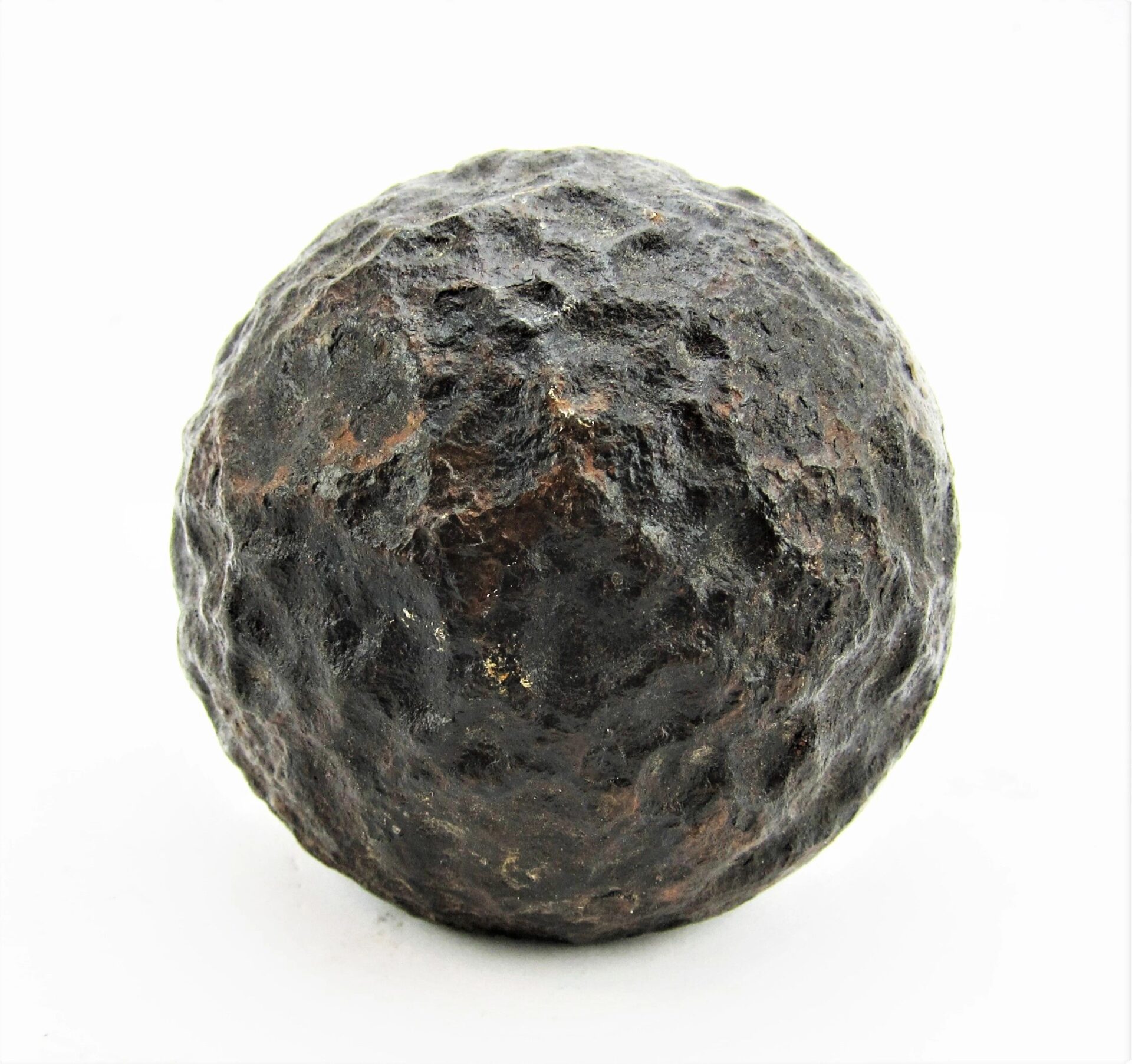 A 6 Pound Bormann Artillery Shell, dark and spherical, is displayed against a plain white background.