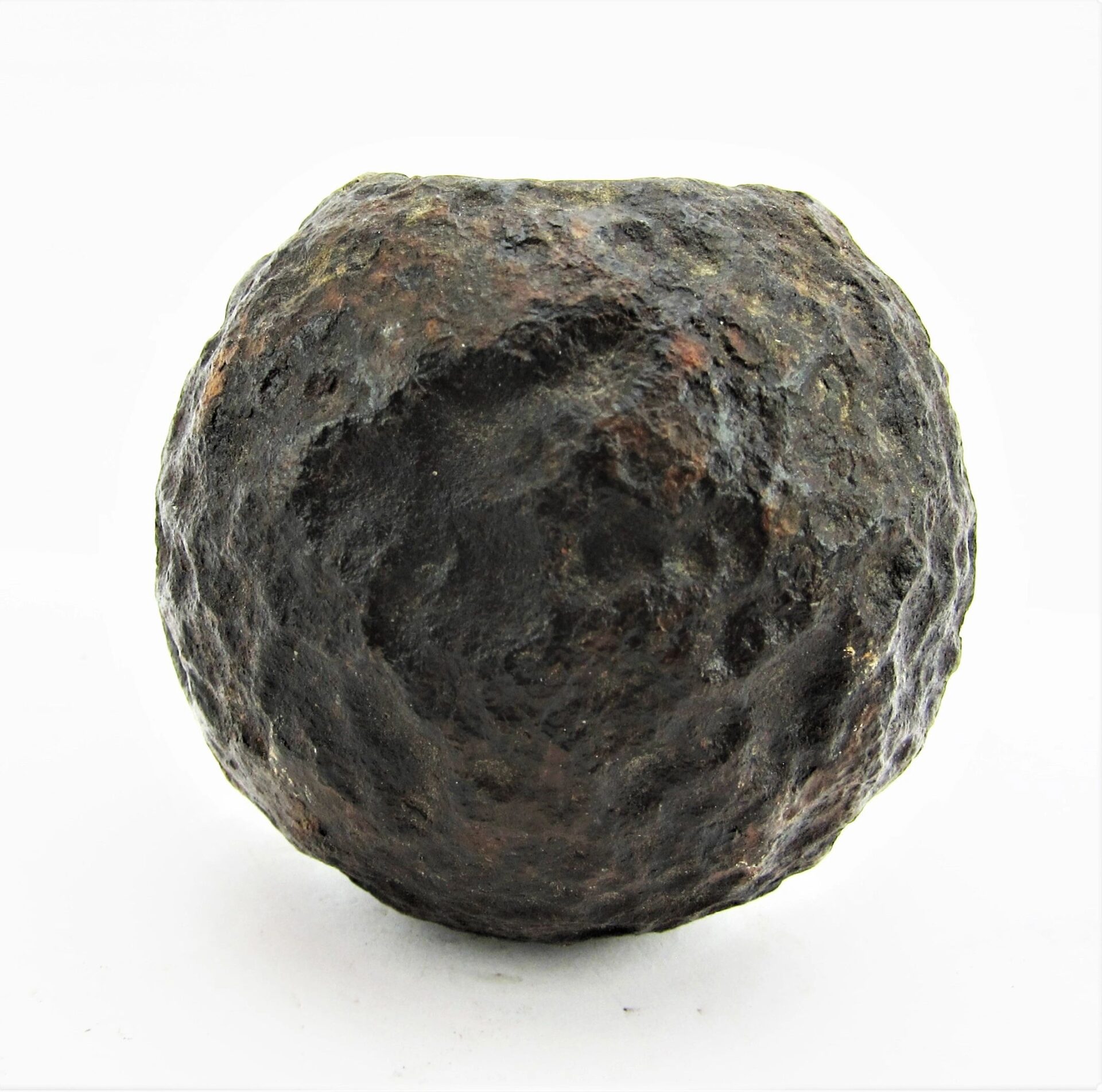A 6 Pound Bormann Artillery Shell, dark and spherical with a textured surface like an old iron cannonball, displayed against a plain white background.