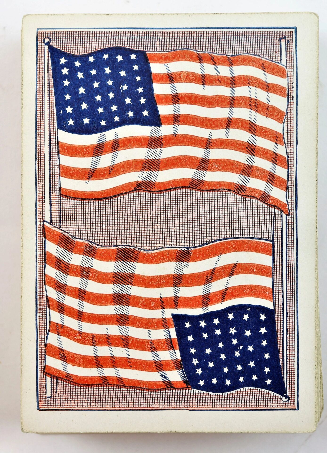 Illustration of two American flags, one above the other, with blue fields, white stars, and red and white stripes, set against a lined background. Featured on Civil War Playing Cards Identified to Private Francis A. Tuck, 17th Massachusetts Infantry / SOLD.