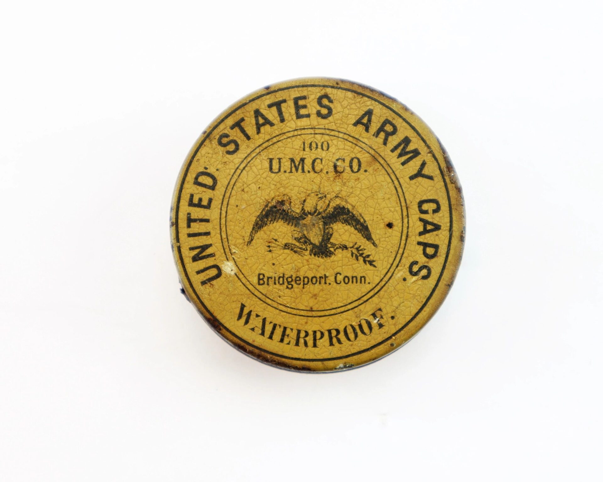 Target Rifle" Box Sharpshooters Display / SOLD—round tin container with an eagle emblem and marked "UNITED STATES ARMY CAPS, WATERPROOF, U.M.C. CO., Bridgeport, Conn."; shown on a white background.