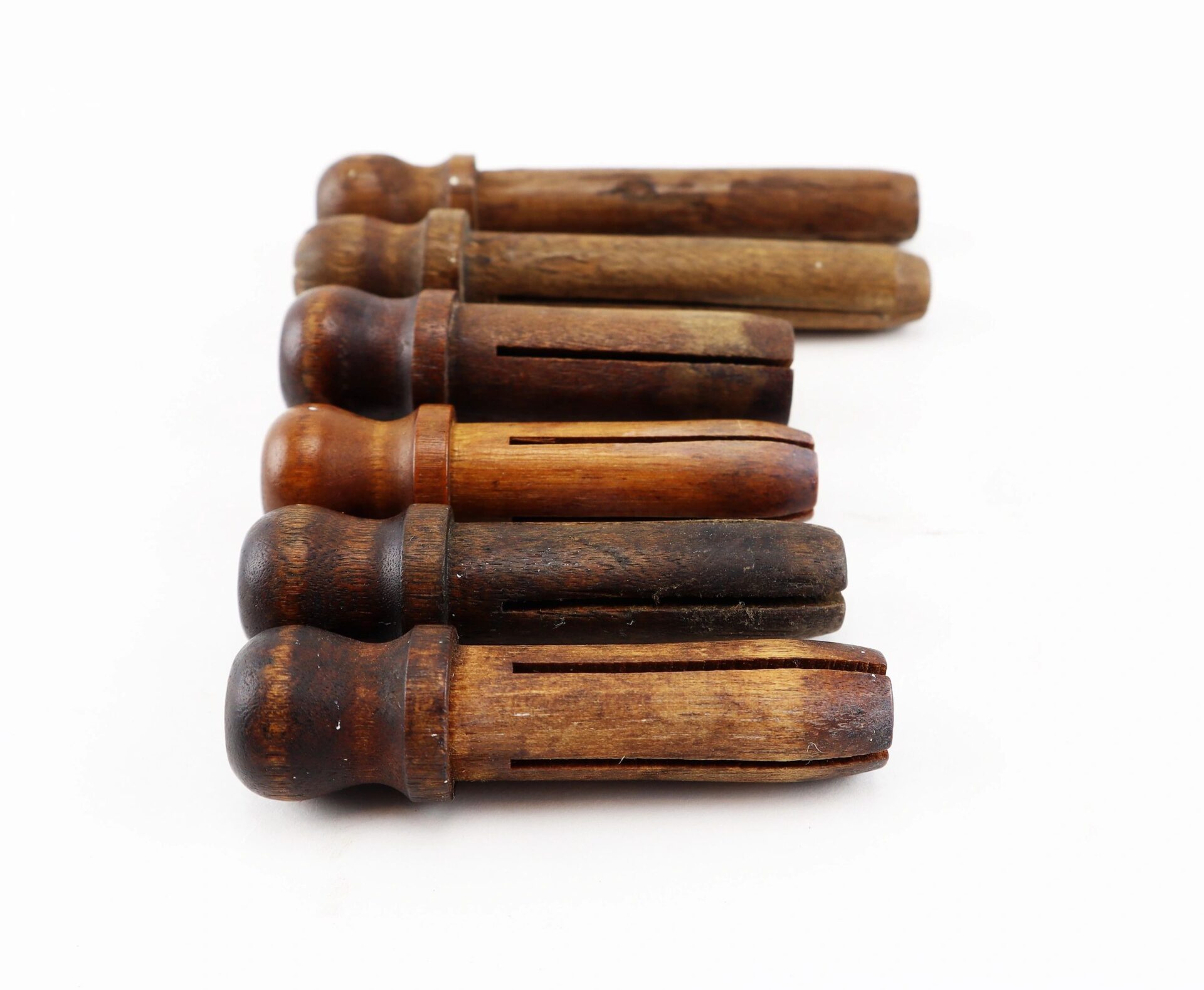 Five vintage Civil War musket tompions arranged in a row on a white background.