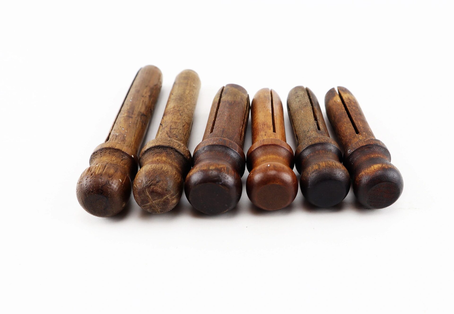 Six Civil War musket tompions are arranged in a row on a white background.