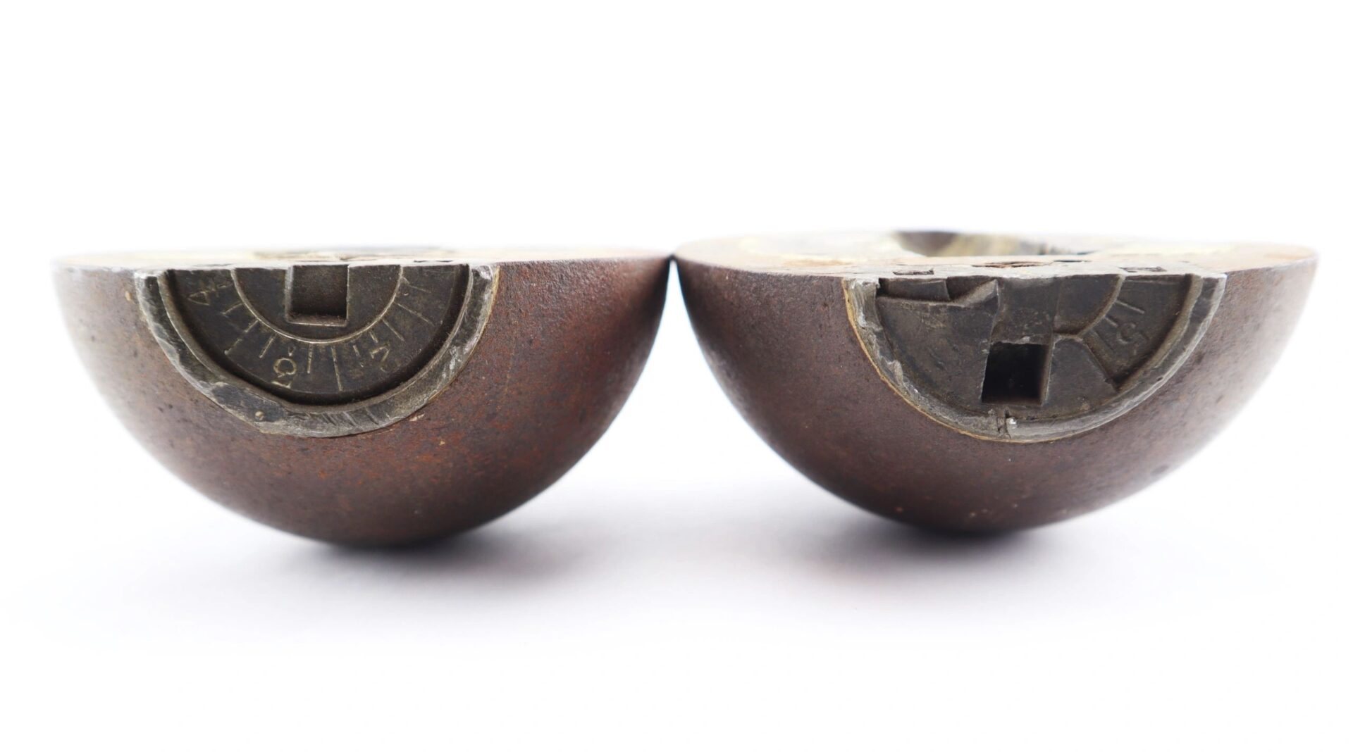 Two Confederate 6 Pound Borman Artillery Shells with exposed mechanical interiors, dials, and slots are placed side by side on a white background.