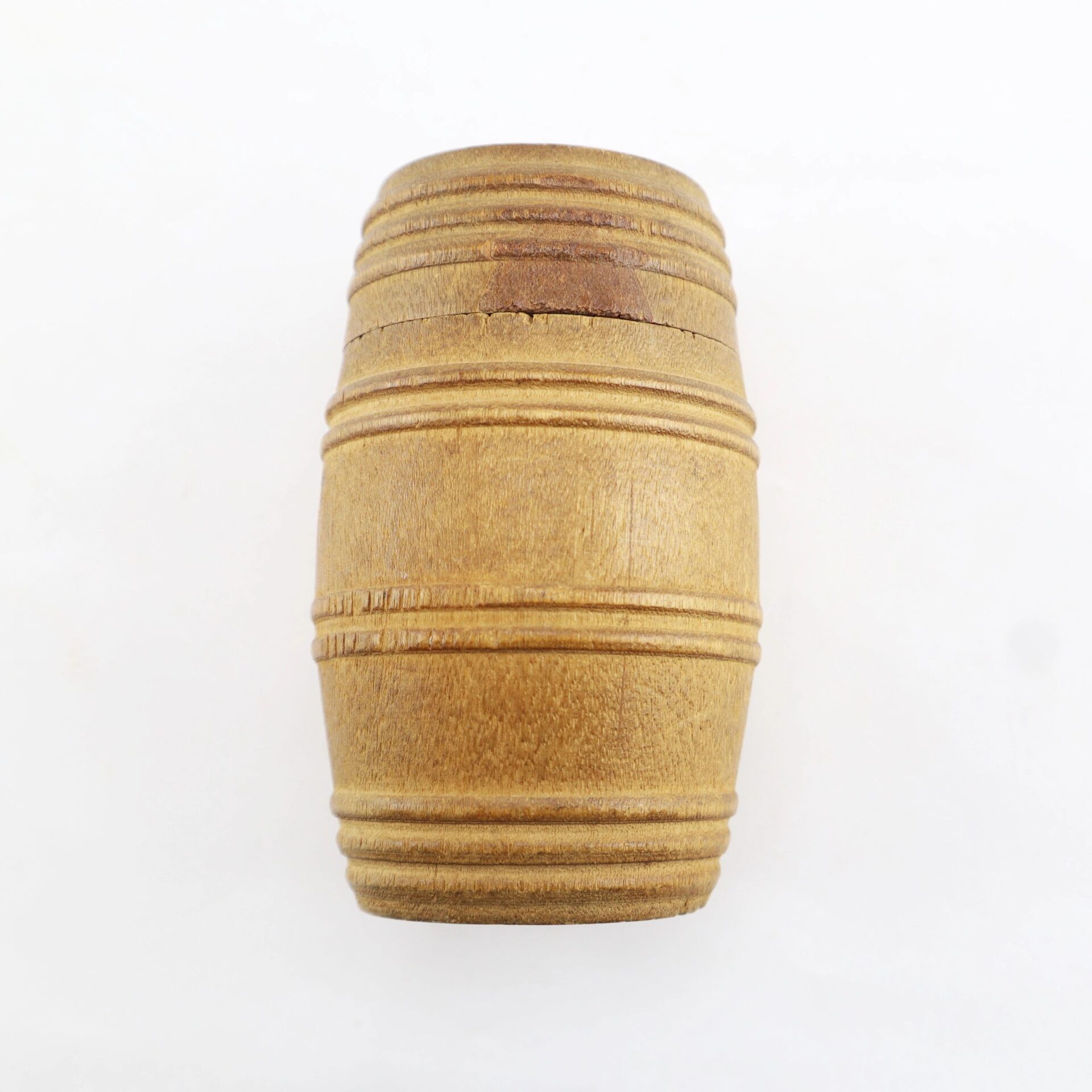 A set of Knucklebones / Sold, shown as small cylindrical wooden barrels with horizontal grooves, photographed against a plain white background.