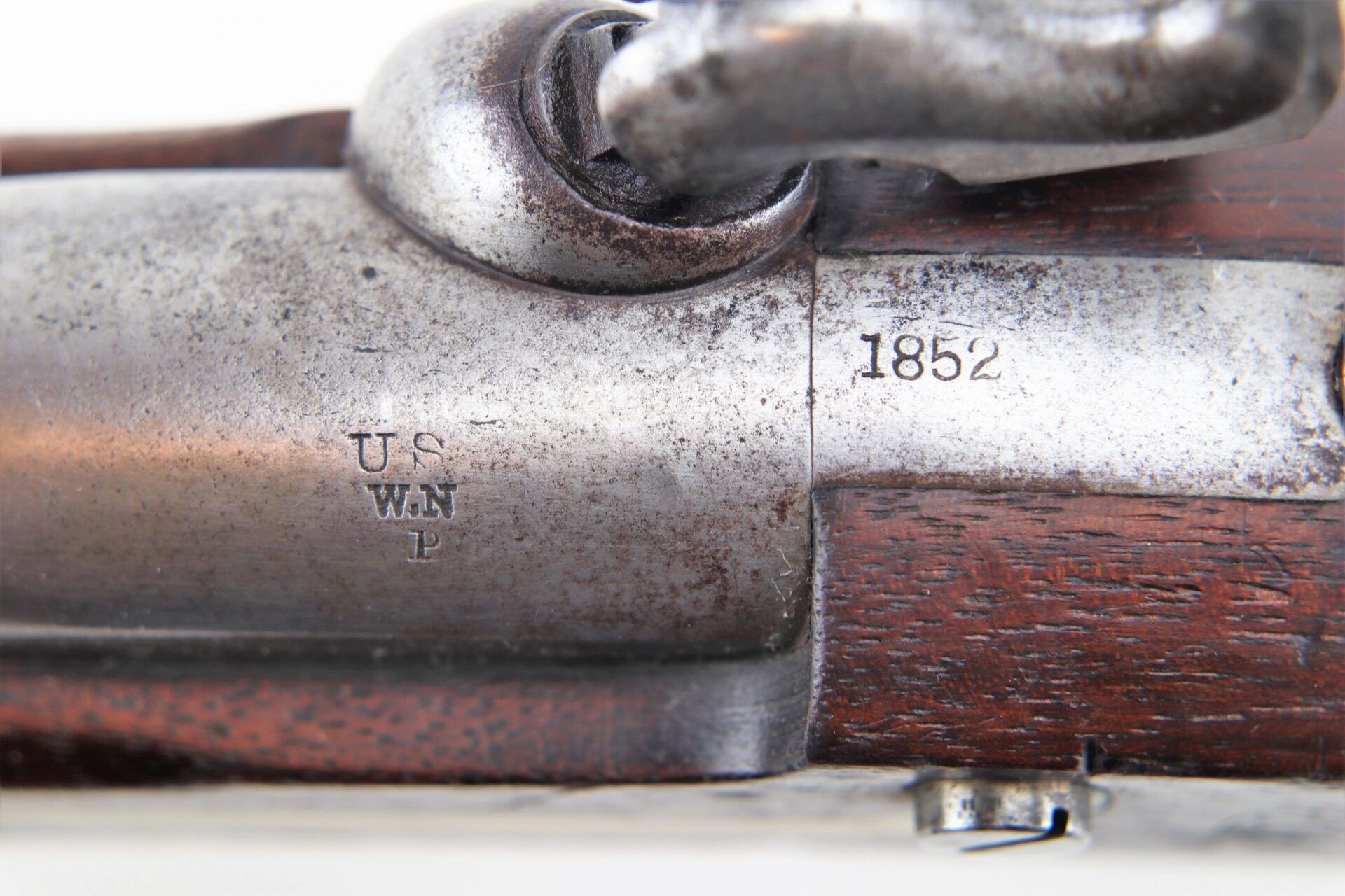 Close-up of an Aston Horse Pistol (SOLD) showing engraved "US WN P" and "1852" markings on its metal surface with a wooden stock.