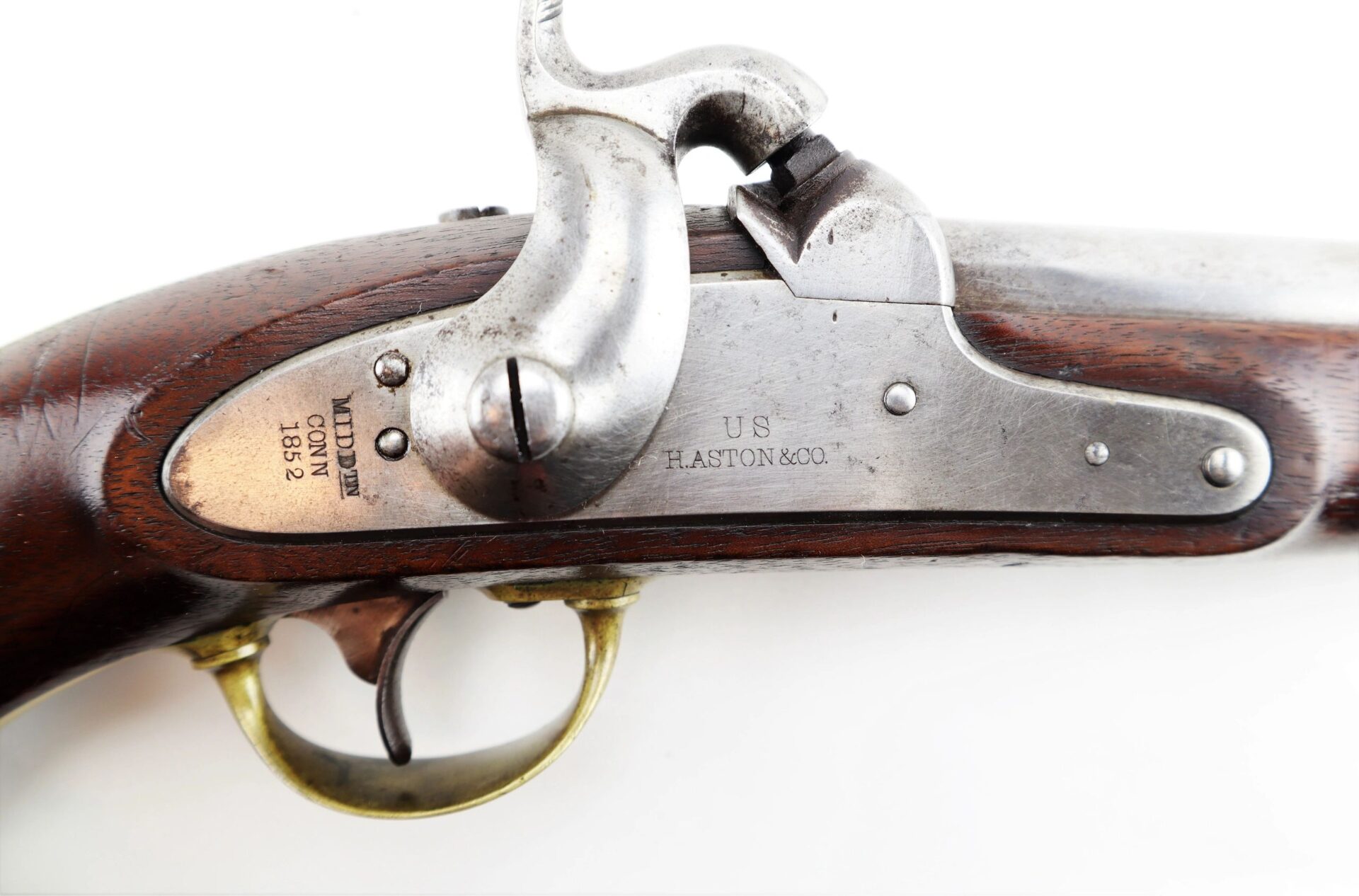 Close-up of an Aston Horse Pistol / SOLD, featuring a wooden grip, brass trigger guard, and engraved metal plate marked “US H. ASTON & CO.” with additional identifying inscriptions.