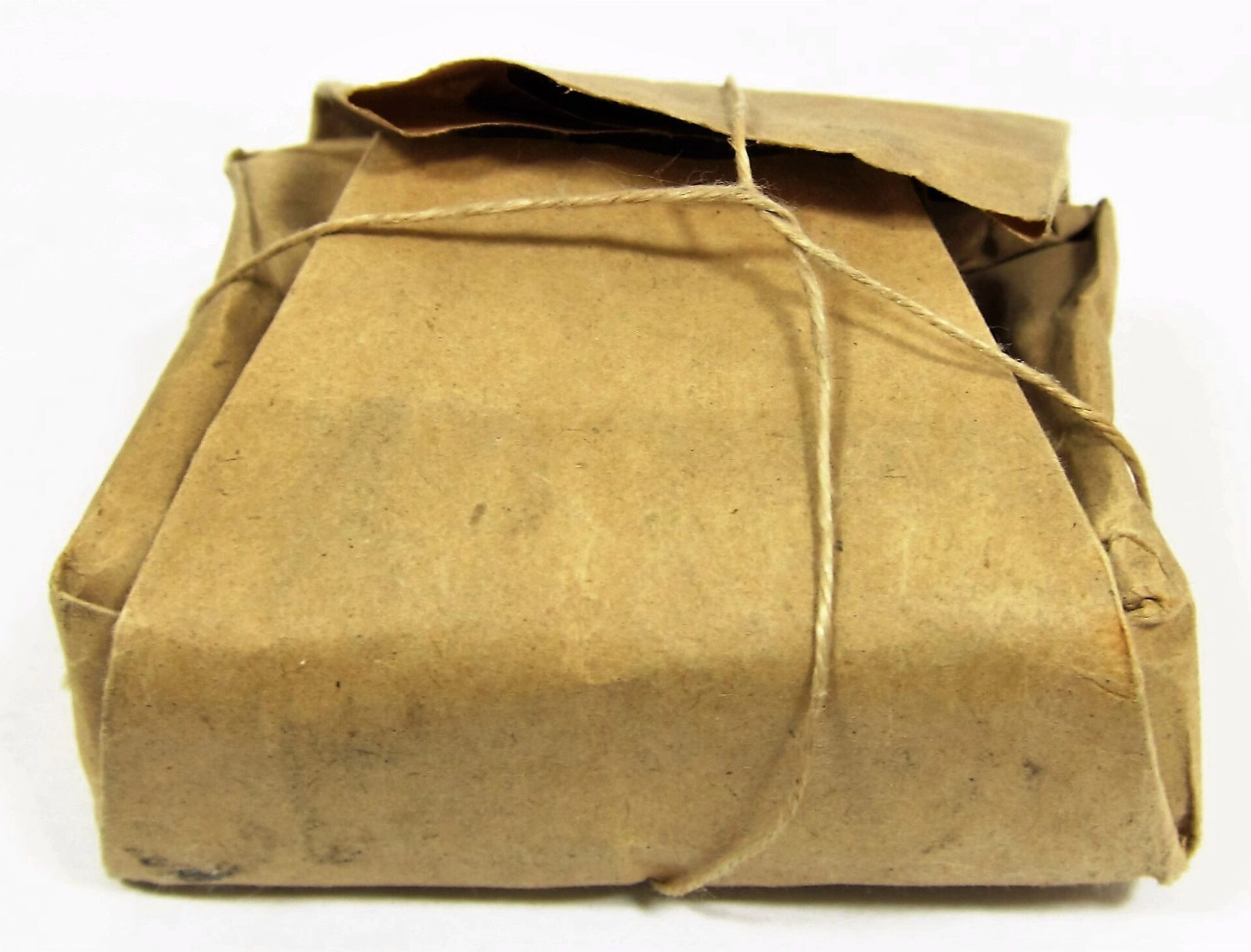 A .58 Caliber Minie Ball Paper Wrapper, now sold, wrapped in brown paper and tied with string, rests on a white surface.