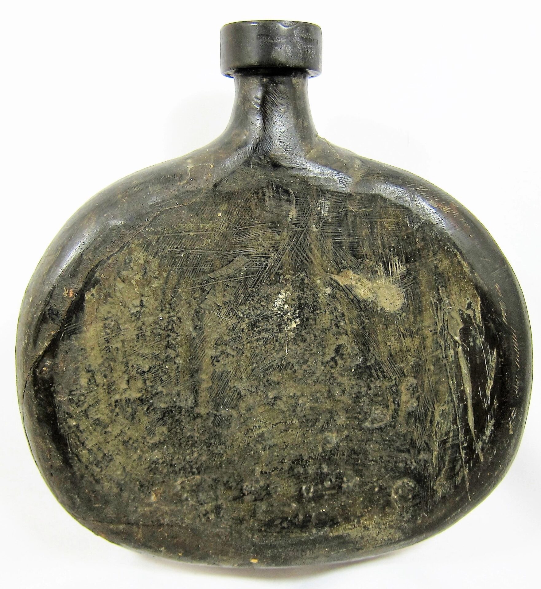 A Civil War Era Gutta-Percha Canteen, round and dark with a short neck and flat, wide body, exhibits scratches and age-related wear. / SOLD.