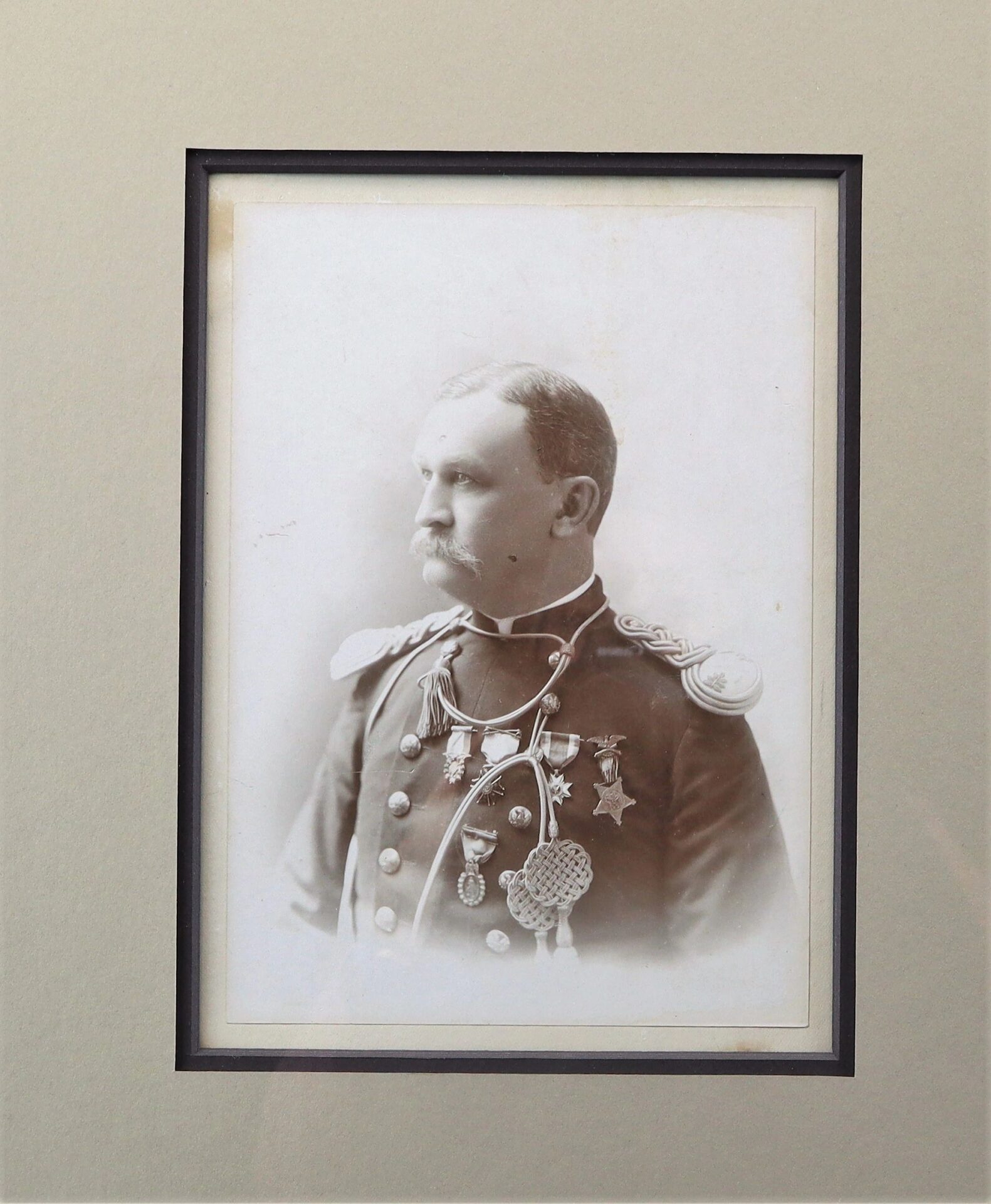 Sepia photograph of Major Erasmus Corwin Gilbreath in a decorated military uniform with medals, shown in profile and mounted in a simple mat frame.