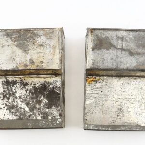 Two .69 Caliber Cartridge Box Tins, rectangular and weathered with visible rust and stains, are placed side by side on a white background.