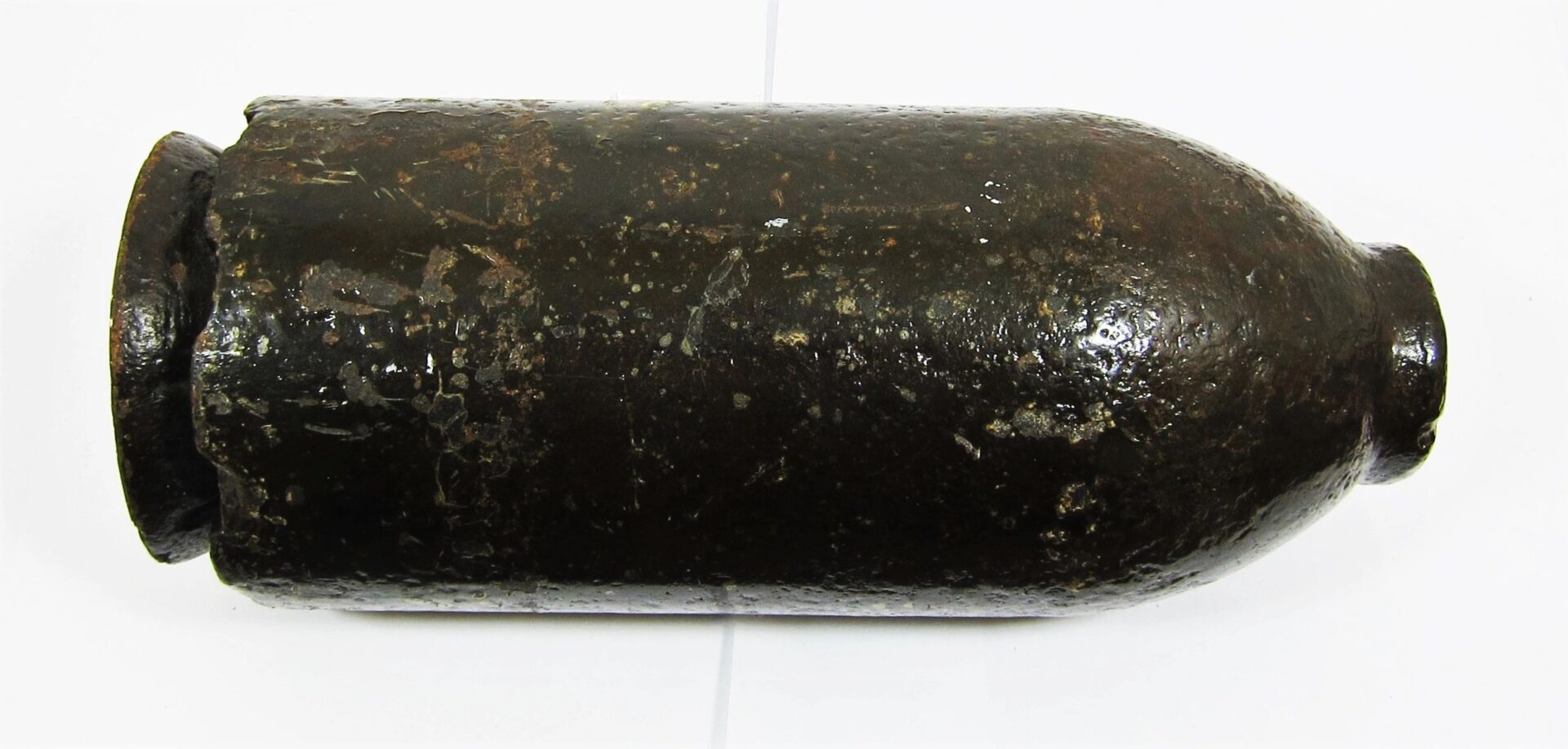 A US 30 Pound Parrott Chilled Nose Bolt, a cylindrical artillery shell, lies horizontally on a white background.