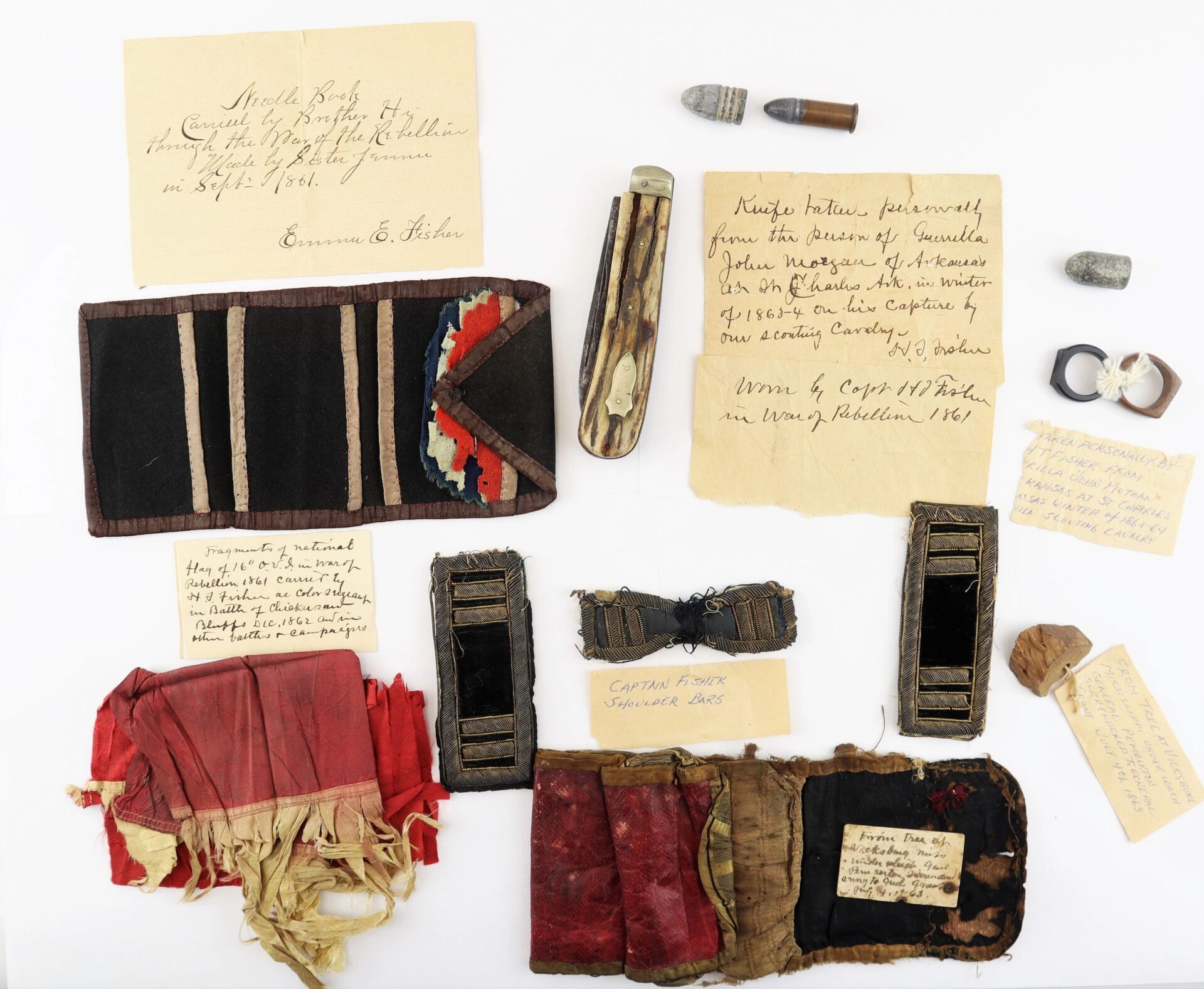 A collection featuring the John Hunt Morgan Knife and items ID’d to Hiram T. Fisher of the 16th Ohio and 53rd USCT, including handwritten notes, medals, bullets, and more, arranged on a white background.
