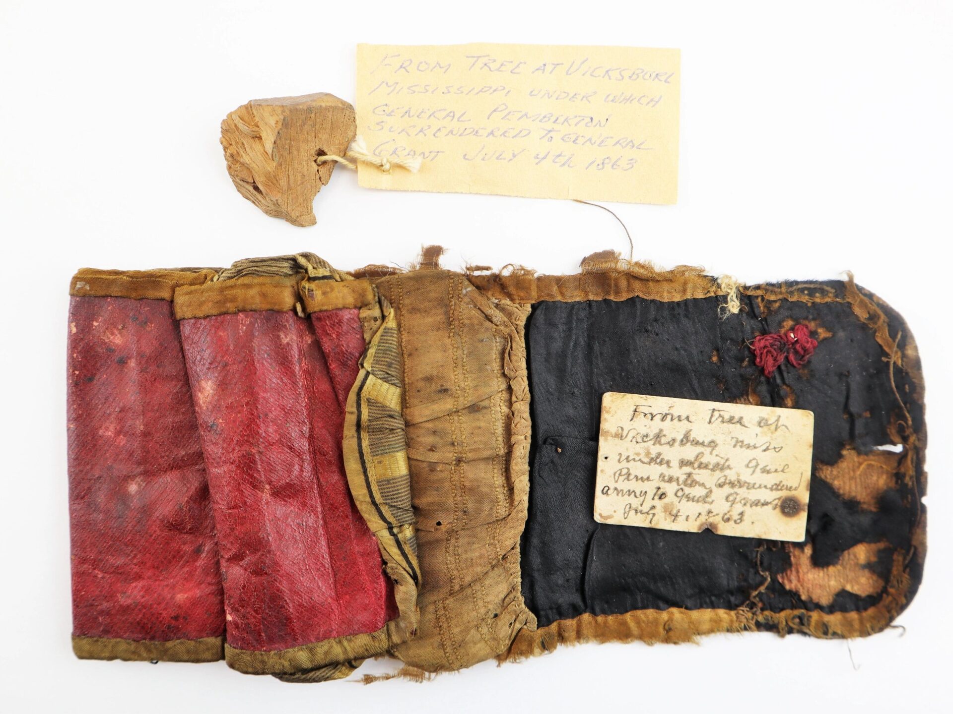 A worn, trifold fabric wallet with red and gold sections plus two handwritten notes about a tree at Vicksburg, Mississippi (July 4, 1863), from the John Hunt Morgan Knife and Grouping ID’d to Hiram T. Fisher, 16th Ohio & 53rd USCT / SOLD.