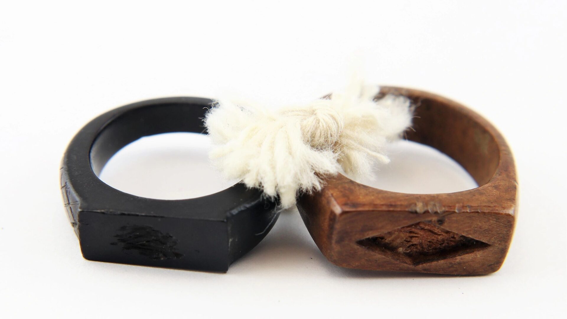 The John Hunt Morgan Knife and Grouping, ID’d to Hiram T. Fisher, 16th Ohio and 53rd USCT, features two engraved rings—one black, one brown—tied together with white yarn and displayed against a white background.
