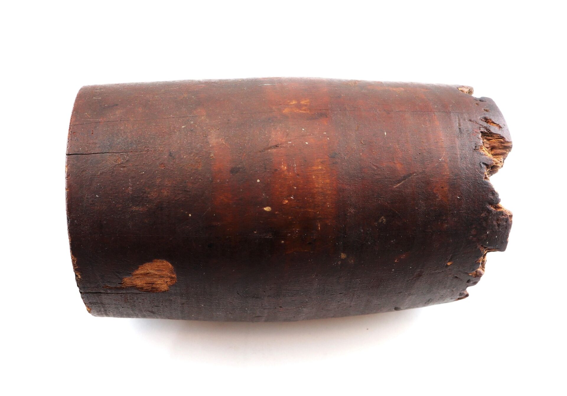A War of 1812 Rundlet Canteen, cylindrical and dark brown with chipped, worn wooden edges, lies on a white background.