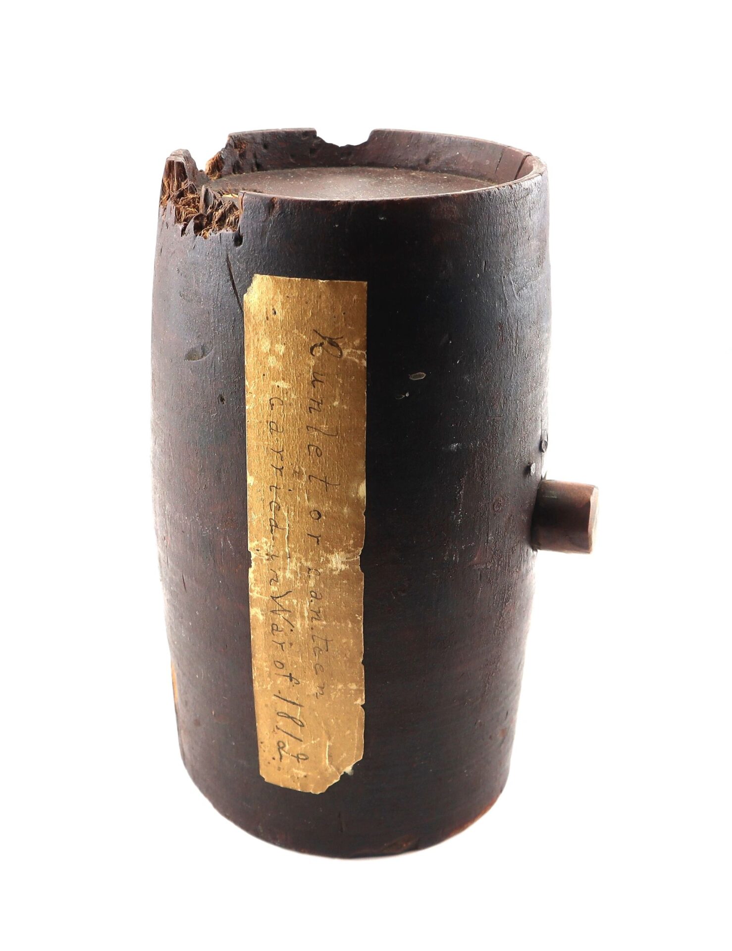 A cylindrical wooden War of 1812 Rundlet Canteen with a chipped top, small side protrusion, and a worn, yellowed label featuring handwritten text.