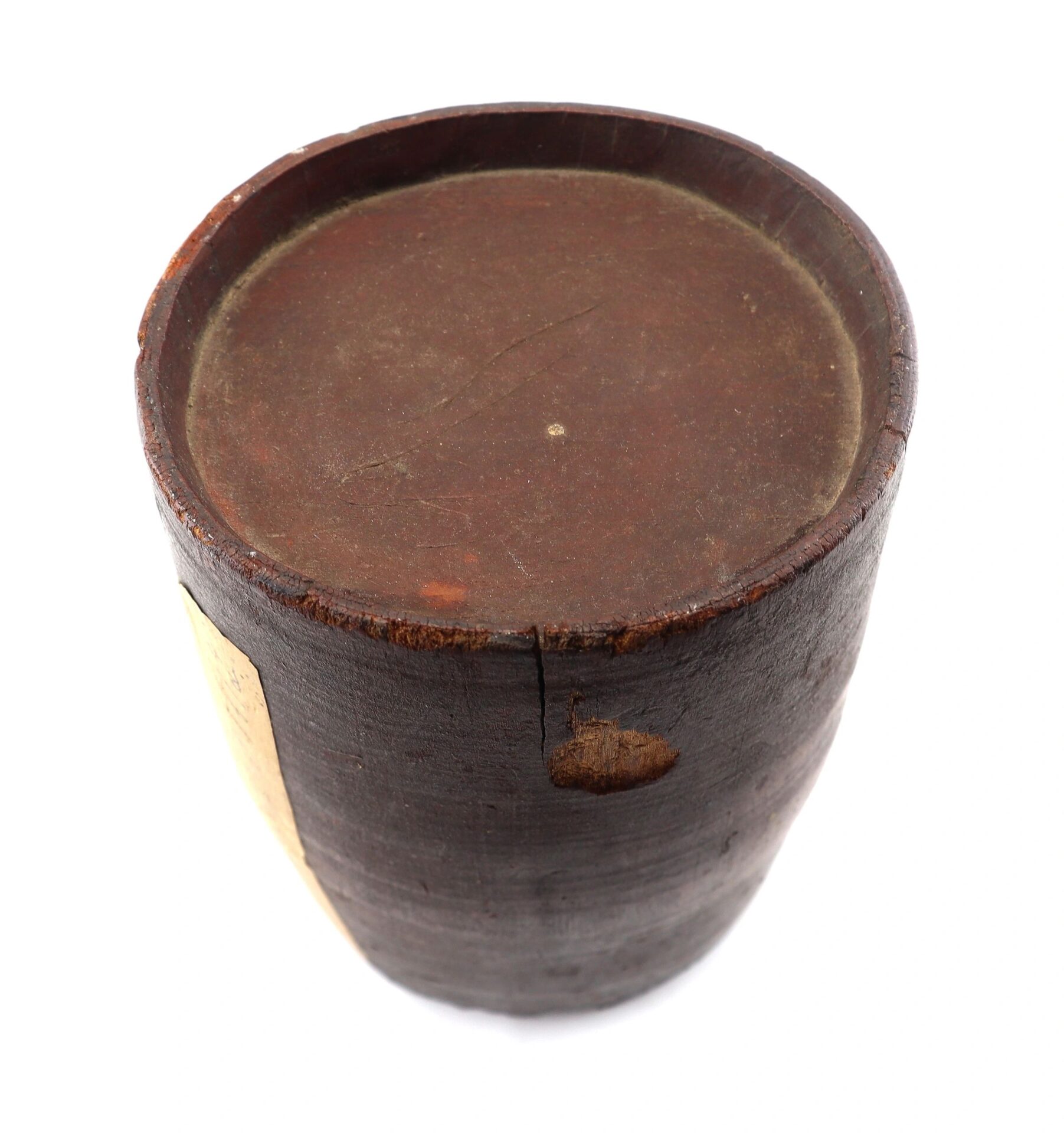 A War of 1812 Rundlet Canteen, a round, dark brown wooden container with a flat, closed top and a visible side crack, is shown against a white background.