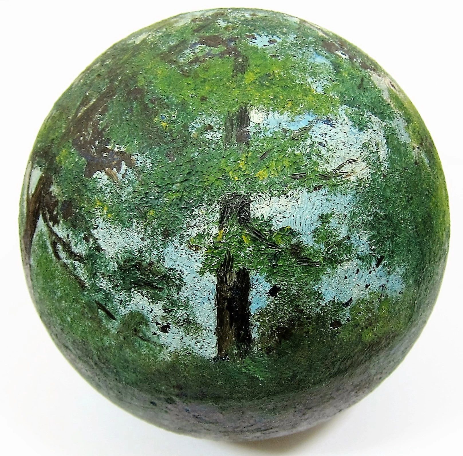 A Painted Cannon Ball featuring a landscape scene with green trees, a blue sky, and a natural outdoor setting.