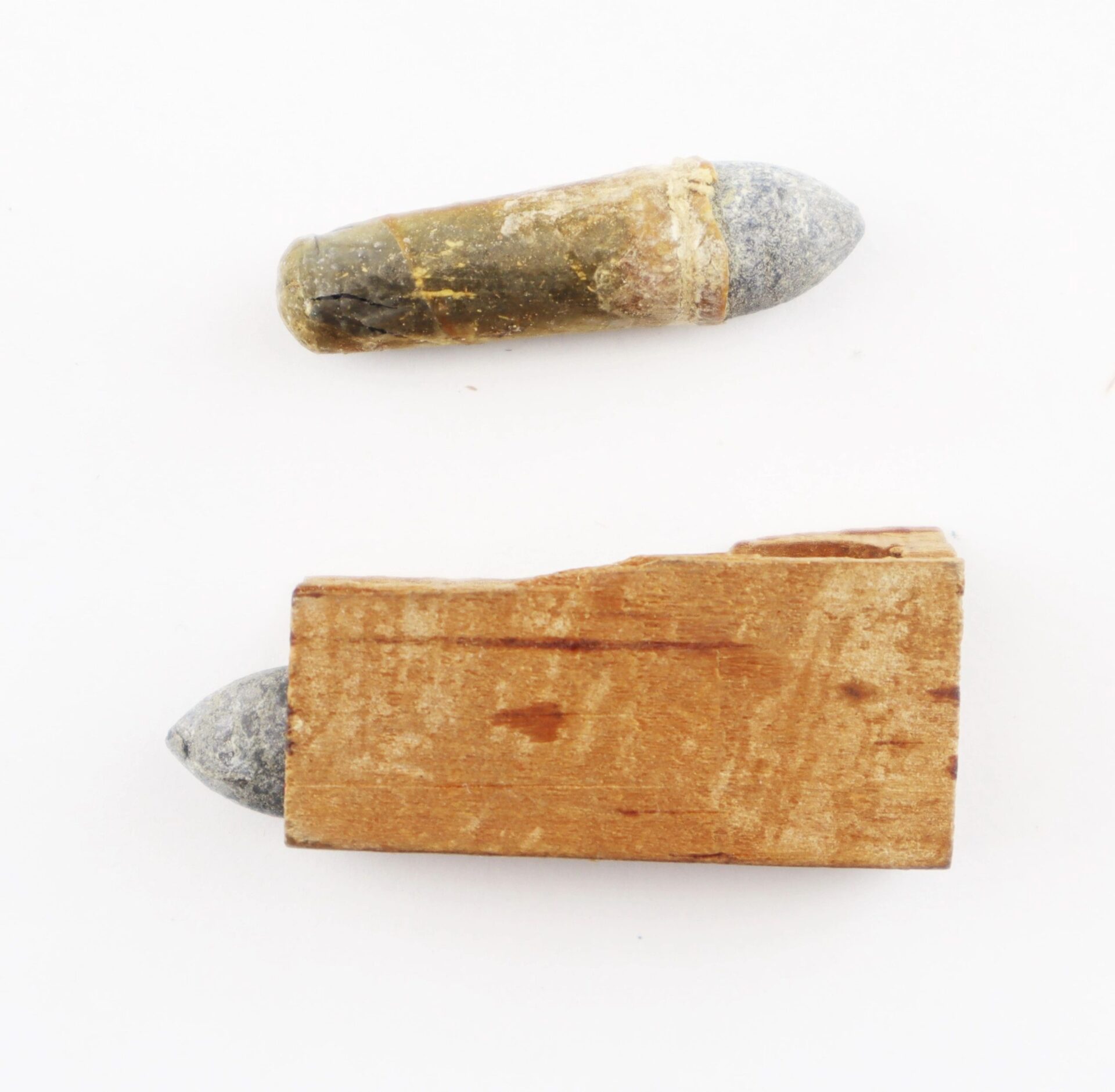 Two .36 Caliber Navy Cartridges / SOLD are displayed: one intact, the other partially encased in a rectangular wood piece. Both show visible gray tips and a weathered look.