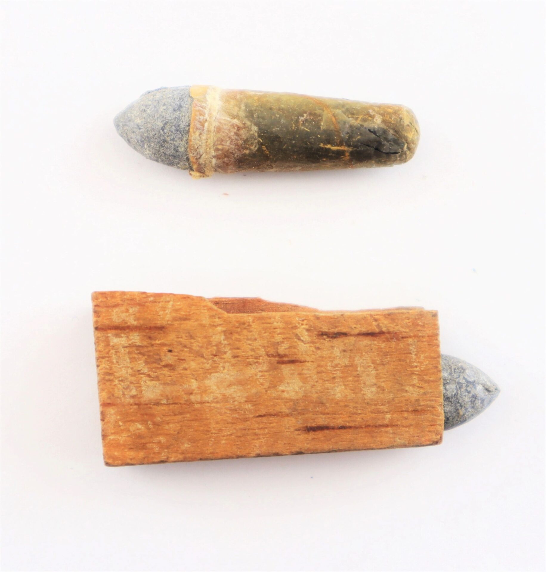 Two .36 Caliber Navy Cartridges are displayed on a plain white background—one with a wooden plug, the other in its wooden cartridge box.