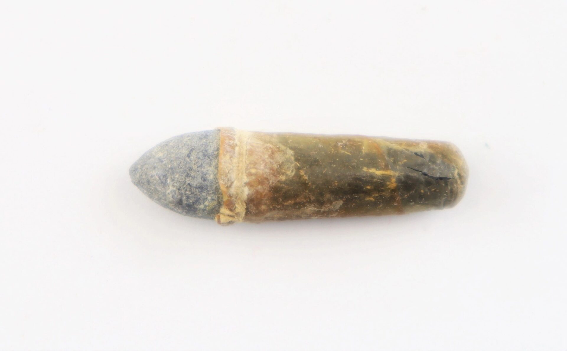A .36 Caliber Navy cartridge with a gray tip and corroded brass casing is displayed on a plain white background.