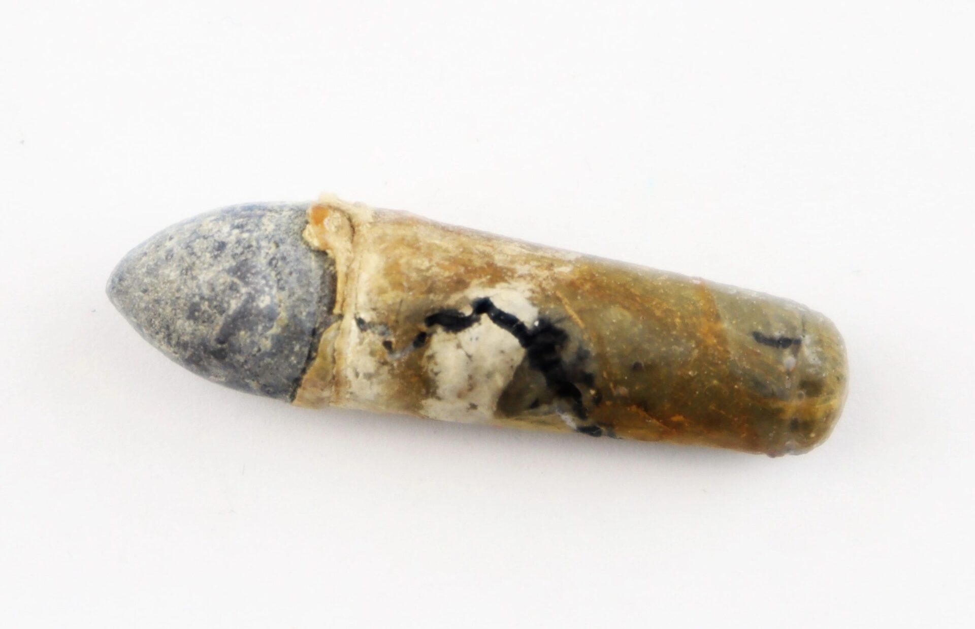 A weathered, partially corroded .36 Caliber Navy Cartridge with a gray pointed tip and a rough, discolored metal casing is shown isolated on a white background.