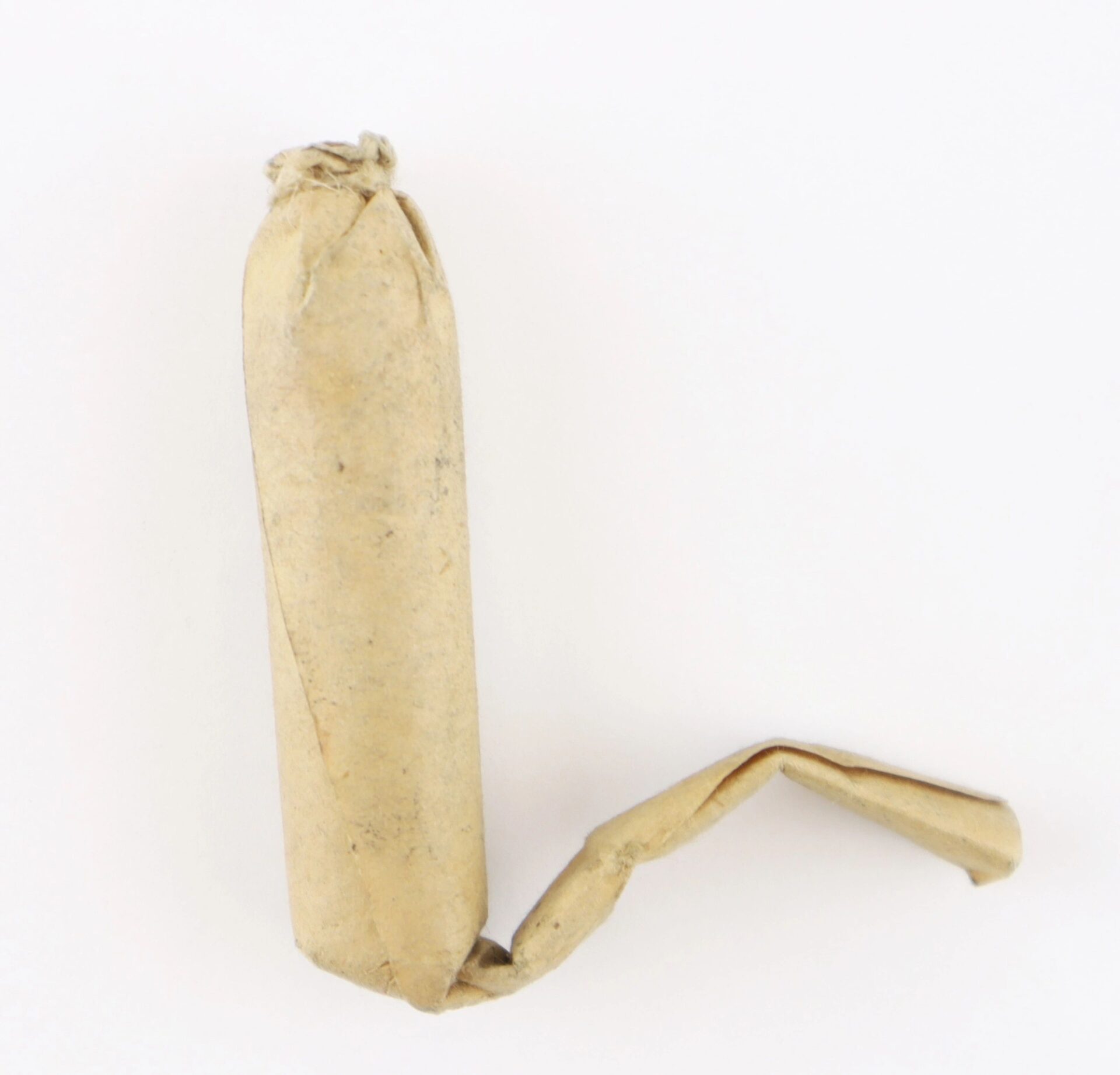 A Civil War .58 Caliber Minie Ball Cartridge, partially unwrapped with twisted brown paper, is displayed on a plain white background.