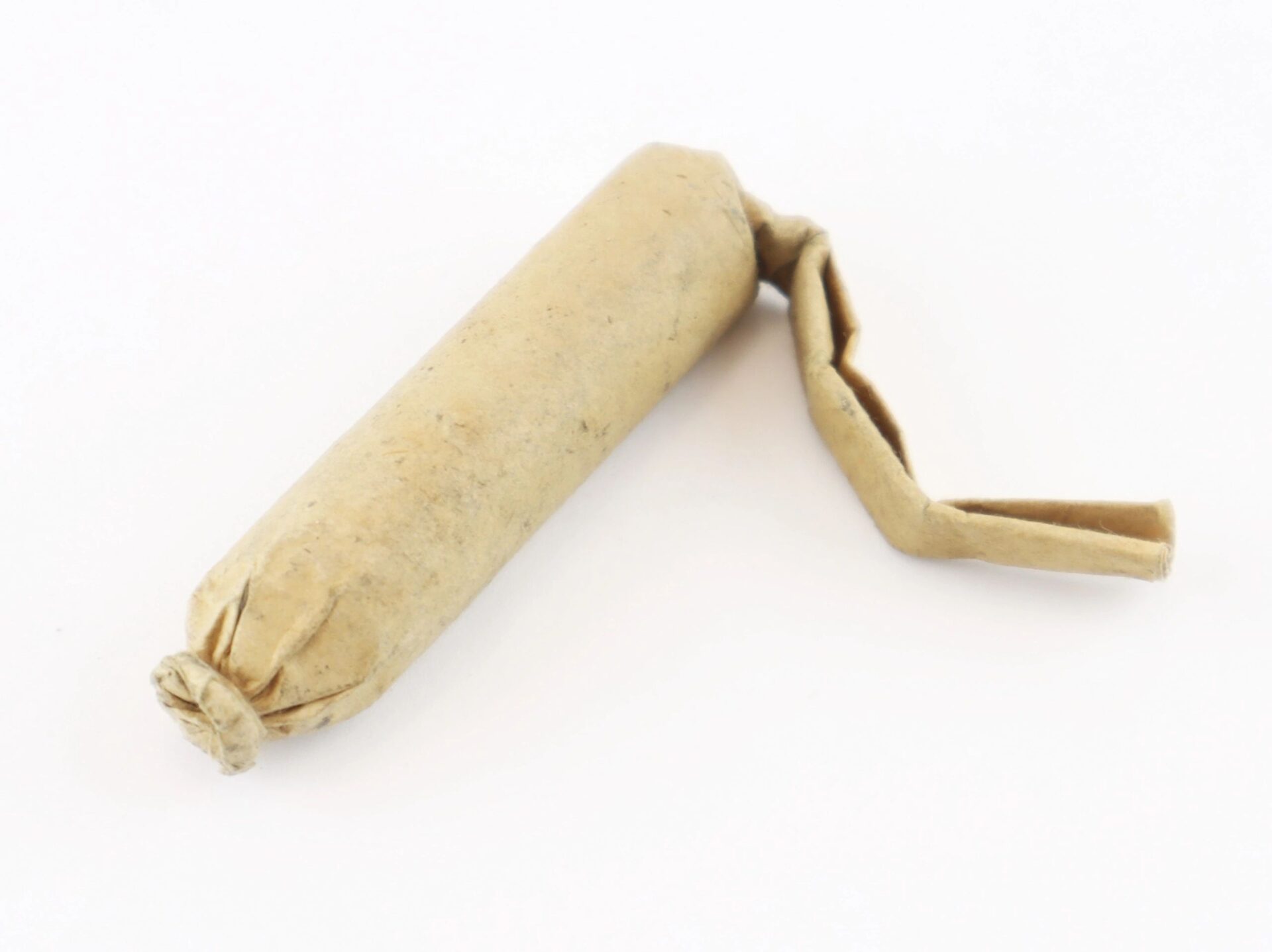A Civil War .58 Caliber Minie Ball Cartridge, SOLD—cylindrical brown paper, one end tied, the other folded flat.