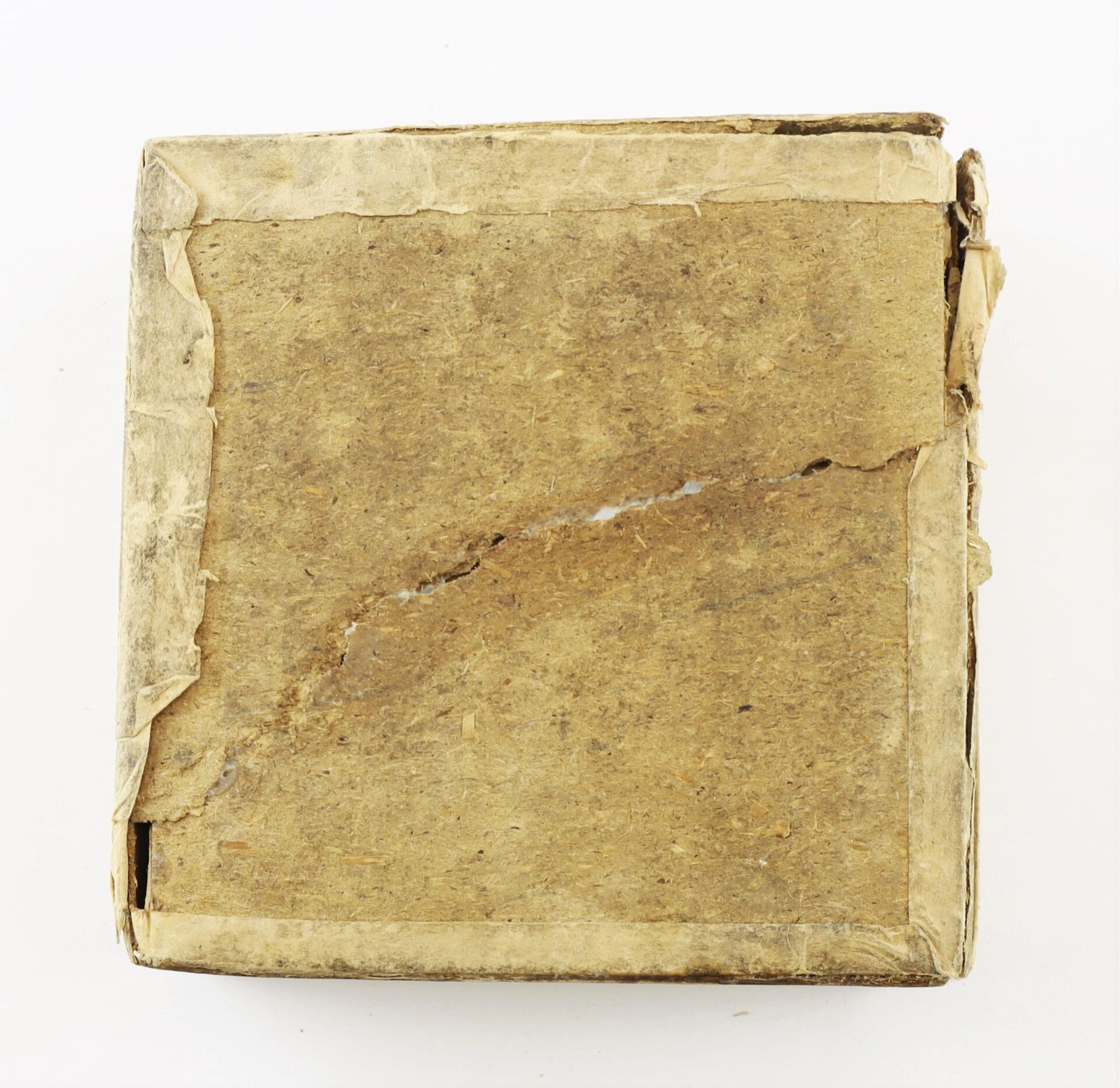 A worn, square, brown cardboard box labeled “Complete Box of 1865 Spencer Cartridges” with visible creases, tears, and rough edges on a white background.