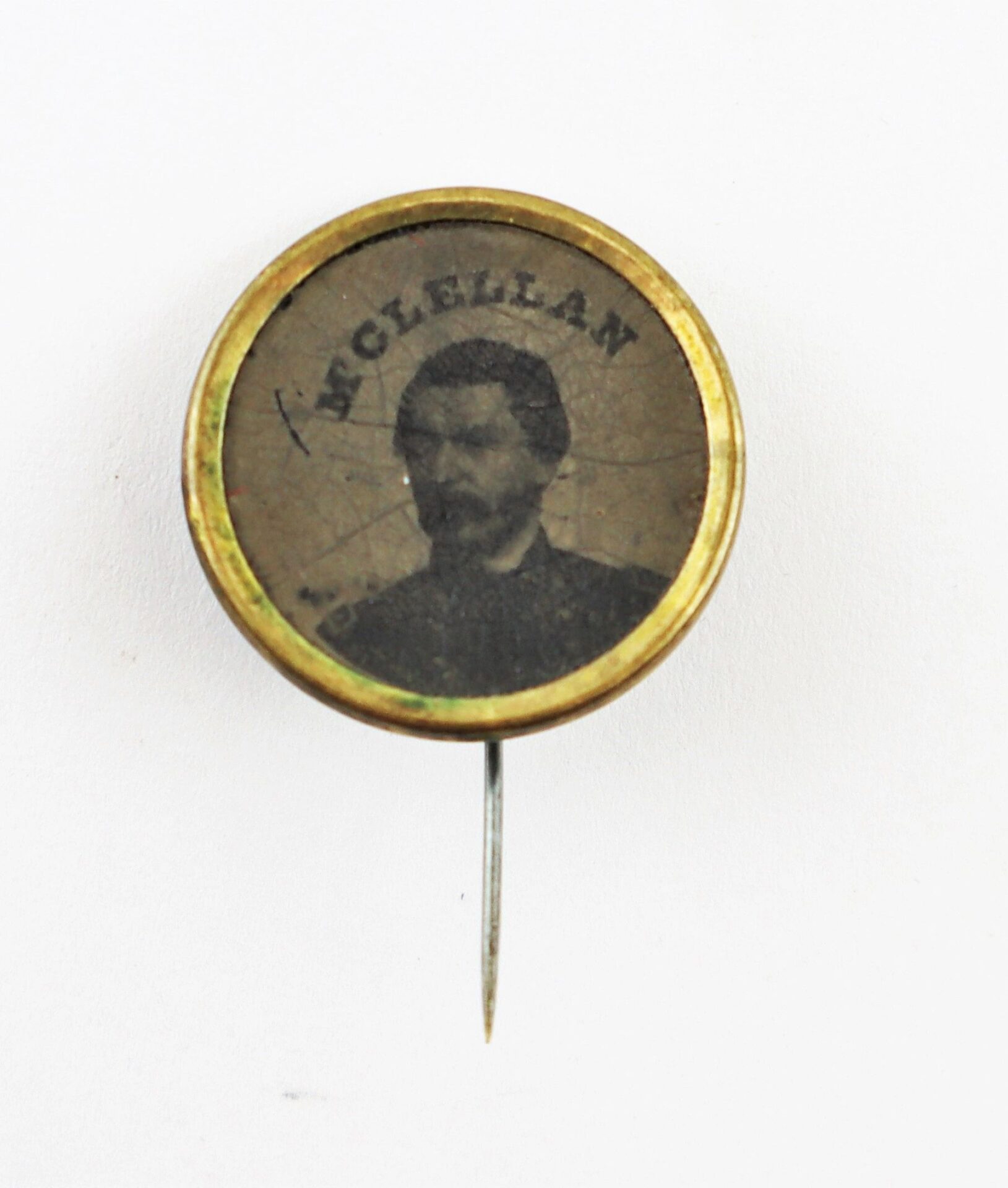 The George McClellan Ferrotype Pin is a vintage campaign pin with a black-and-white portrait of McClellan set in a circular metal frame and pin backing.