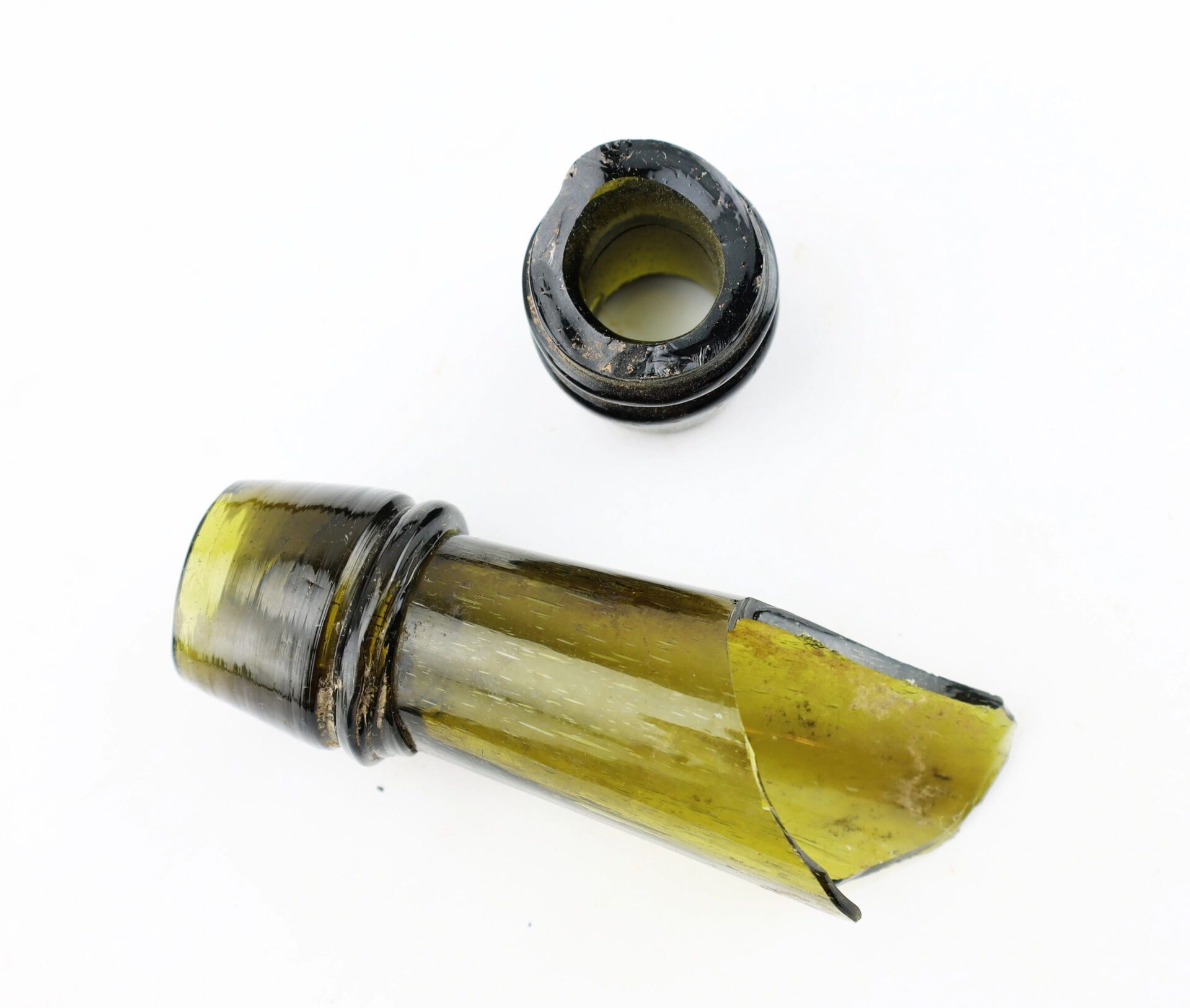 Broken neck of a green Mrs. S.A. Adams Worlds Hair Balsam Bottle from Brandy Station, Virginia with detached top piece on a white background.