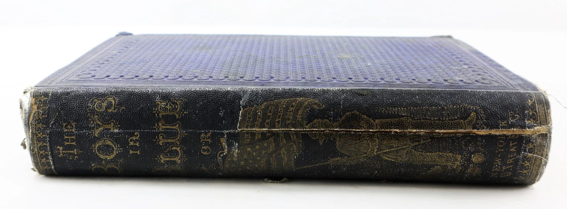 A worn hardcover titled "The Boys in Blue by A. H. Hoge" lies flat, showing spine damage and gold embossed lettering and illustration. / SOLD.