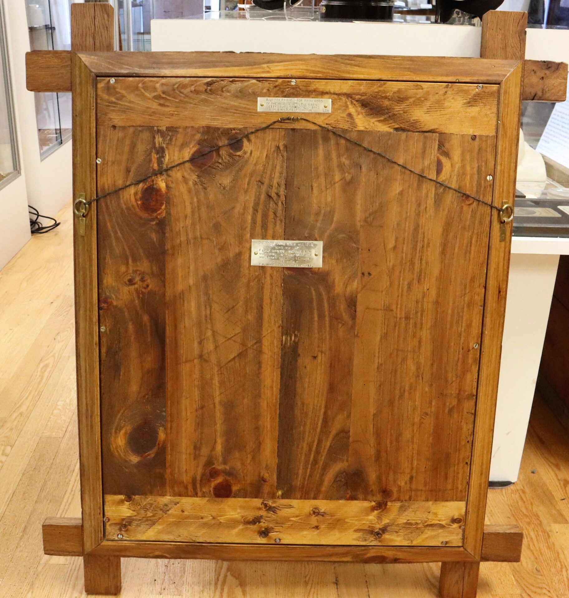 The back of the Flank Marker Flag 2nd Regiment New York State Militia (82nd NY Infantry), with wood grain frame, two metal plaques, and hanging wire, rests on a light wood floor indoors. Battle of Antietam & Gettysburg! / SOLD.