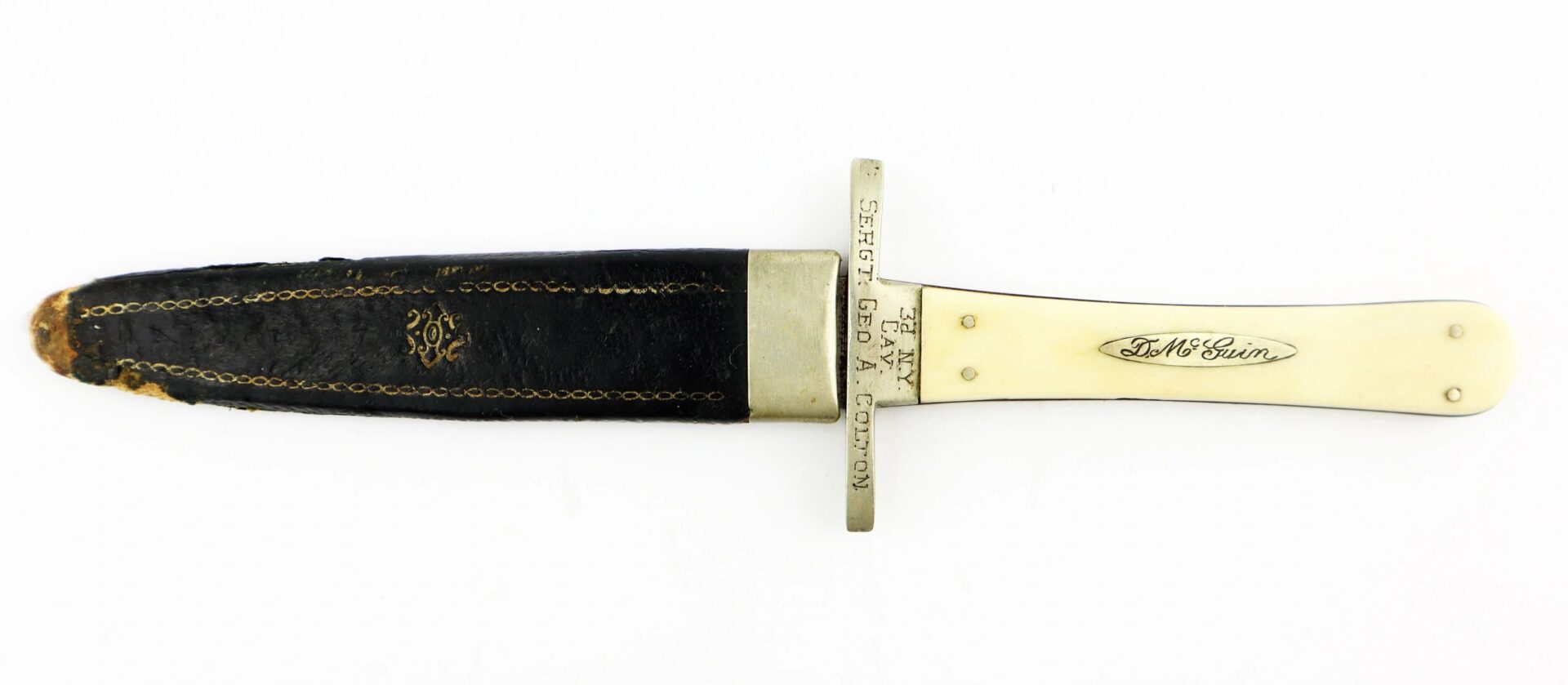 A Sheffield Dagger picked up at Tranter’s Creek, North Carolina by Sgt. George A. Colton, 3rd NY Cavalry/SOD, featuring a white handle, engraved guard, and black leather sheath, displayed on a white background.
