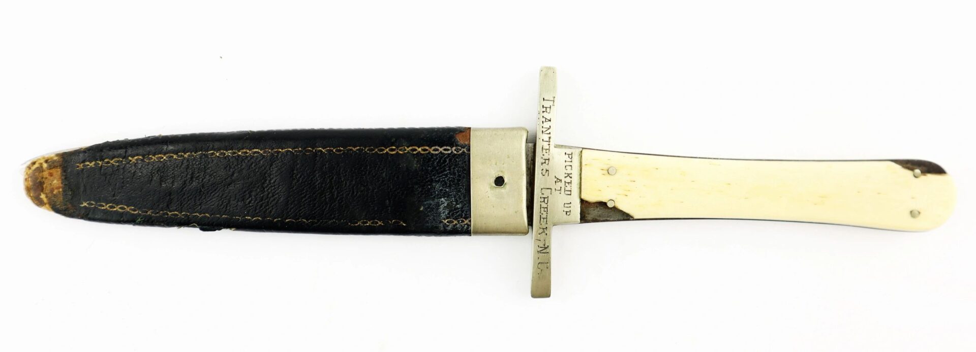 A Sheffield Dagger with an ivory-colored handle, metal guard, and black leather sheath—picked up at Tranter’s Creek, North Carolina by Sergeant George A. Colton, 3rd New York Cavalry/SOD—is displayed on a white background.