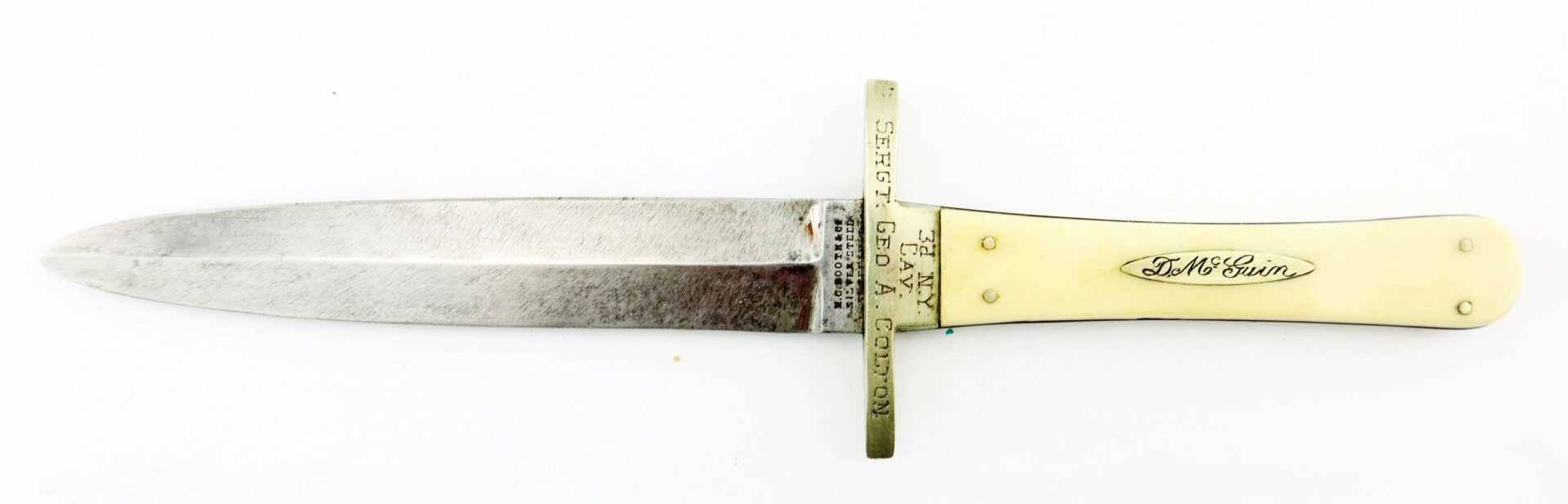 The Sheffield Dagger, picked up at Tranter’s Creek, NC by Sgt. George A. Colton, 3rd NY Cavalry/SOD, features a double-edged steel blade, brass inscribed crossguard, and an ivory-colored handle with an engraved nameplate.