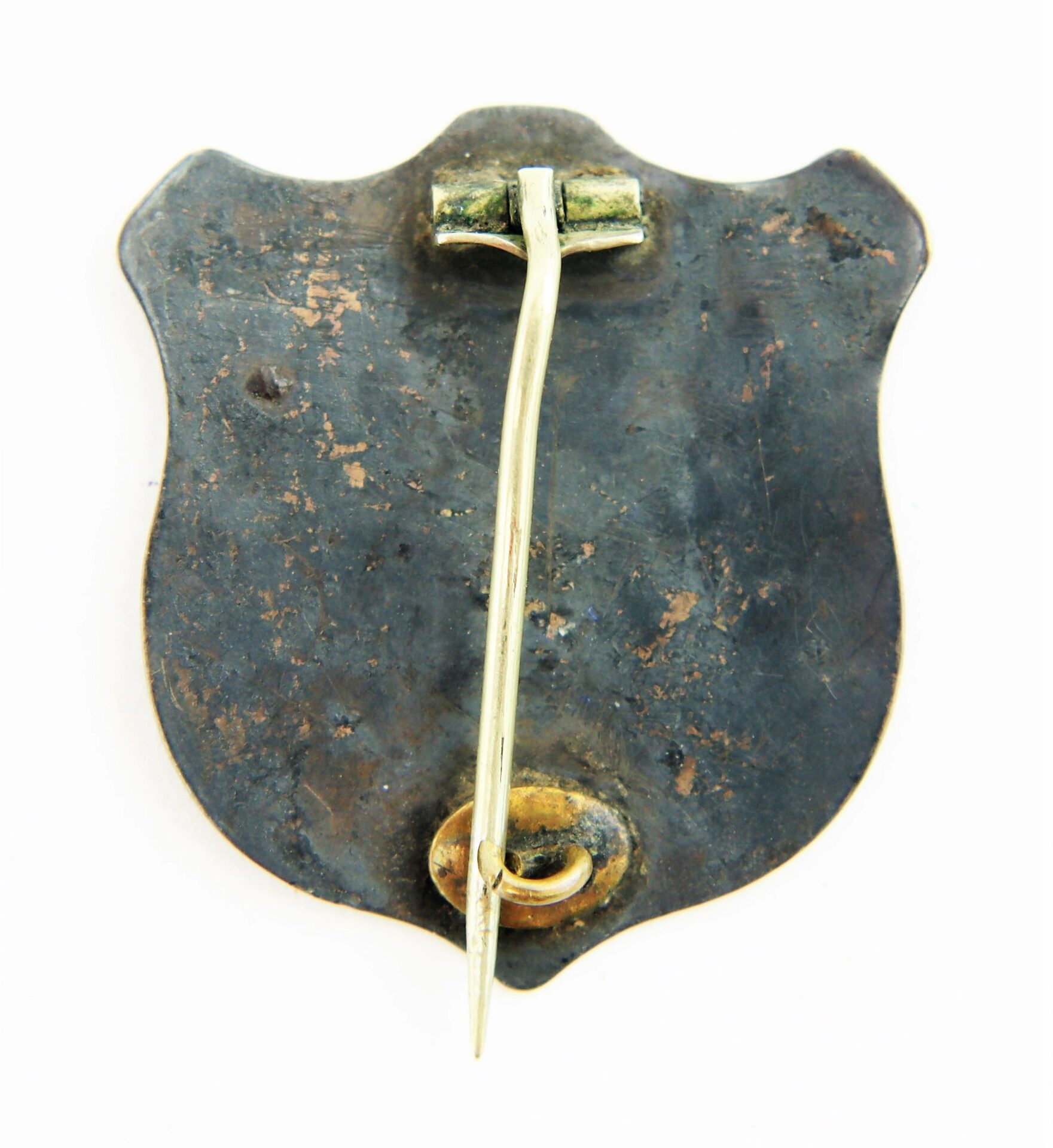 The reverse of the Identification Badge and Discharge of Private Joseph W. Herrick, 13th New York Infantry, shows a tarnished shield-shaped metal pin with a long vertical fastener and hinge mechanism at the top.